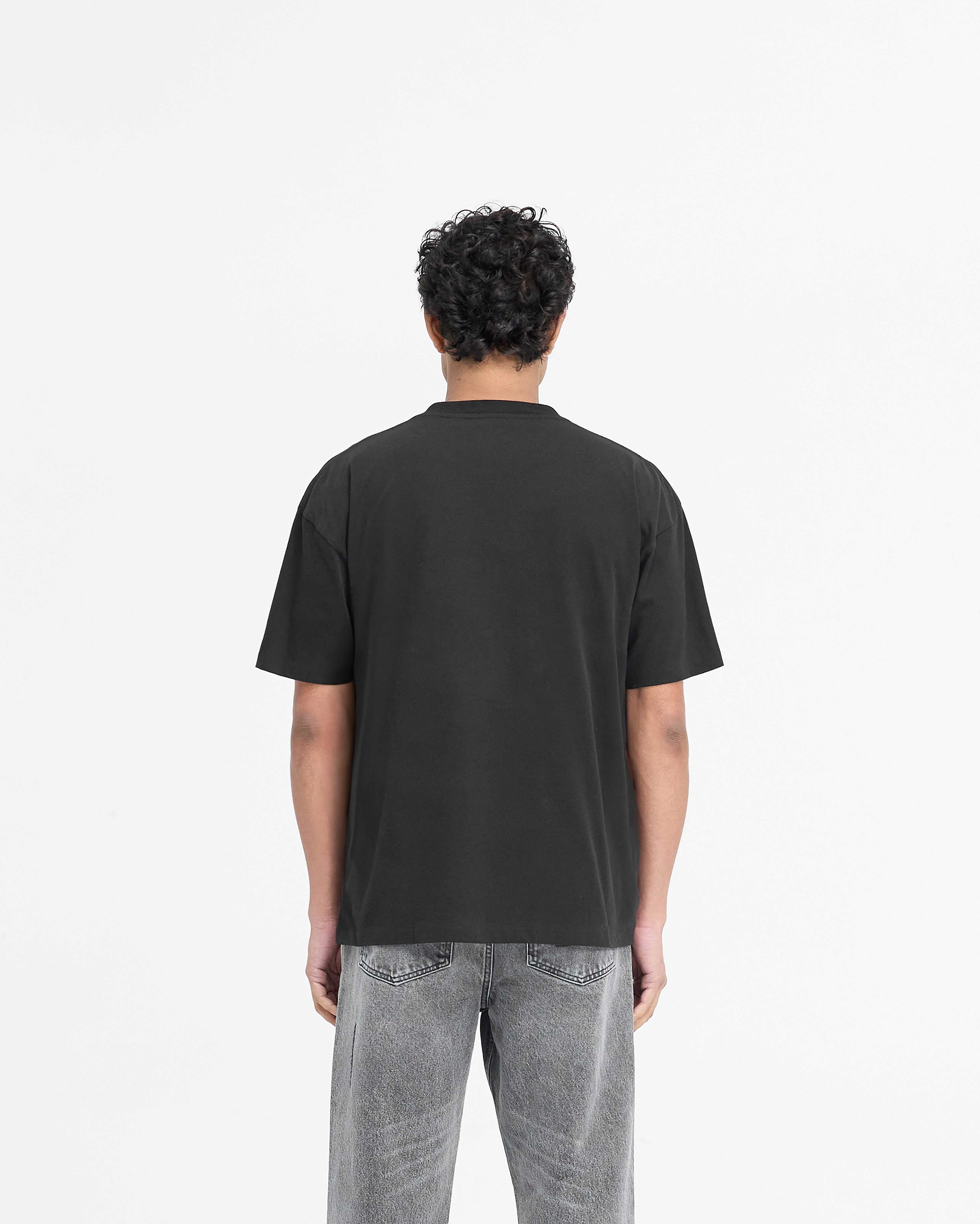 Man wearing a black t-shirt on a plain white background | Serif Logo T-Shirt in Jet Black | Slightly oversized t-shirt with embroidered branding | PRE SS25 T-Shirts | Represent Clo