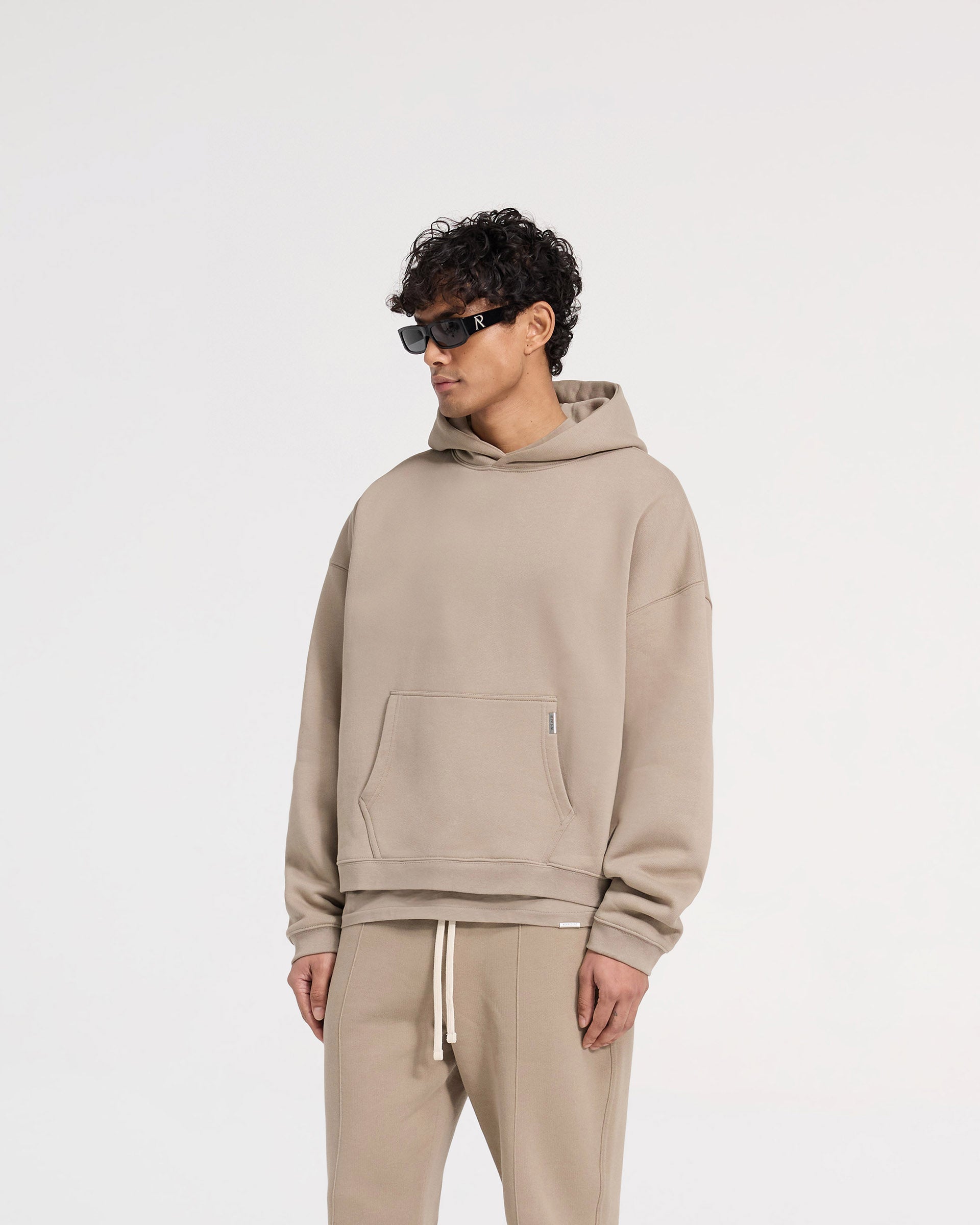 Back product image of a mens beige hoodie on a plain white background | Initial Boxy Hoodie in Dune | Oversized boxy hoodie with dropped shoulders | Initial Hoodies | Represent Clo