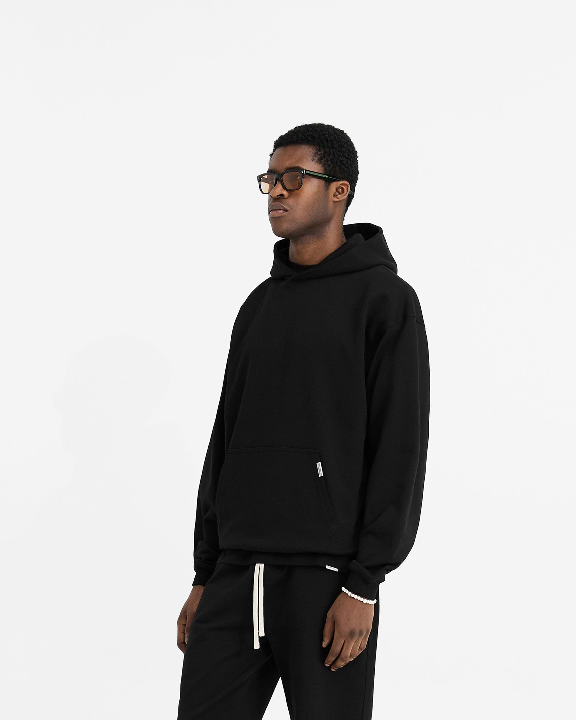 Back product image of a mens black hoodie on a plain white background | Initial Oversized Hoodie in Black | Hoodie with 1x1 rib and kangaroo pocket | Initial Hoodies | Represent Clo