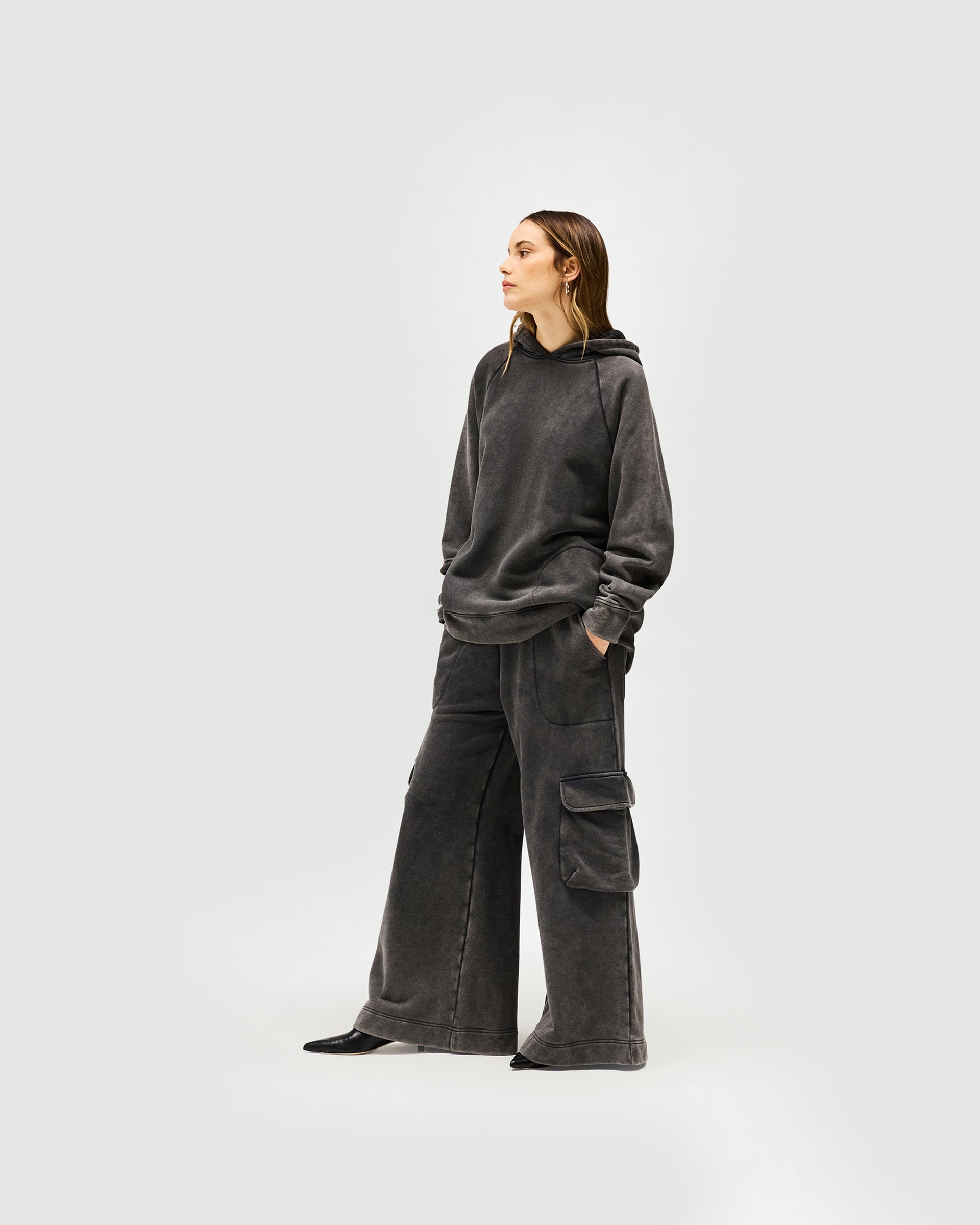 Woman wearing an oversized charcoal hoodie on a plain white background | Monster Hoodie in Charcoal | Oversized hoodie with dropped sleeves | Womens SS25 Hoodies | Represent Clo