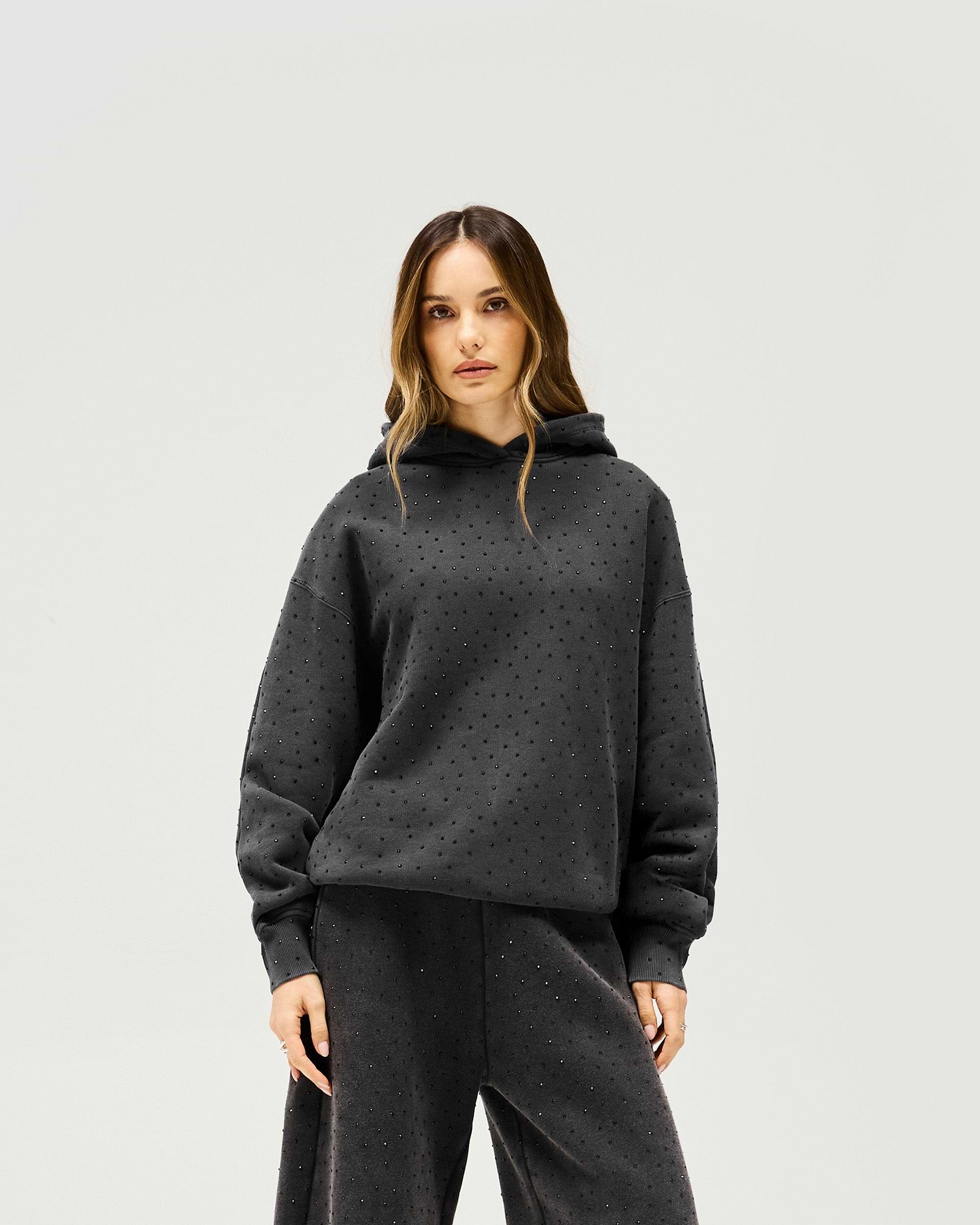 Woman wearing an oversized grey hoodie on a plain white background | Spark Hoodie in Washed Grey | Slouchy hoodie with all over hotfix | Womens SS25 Hoodies | Represent Clo