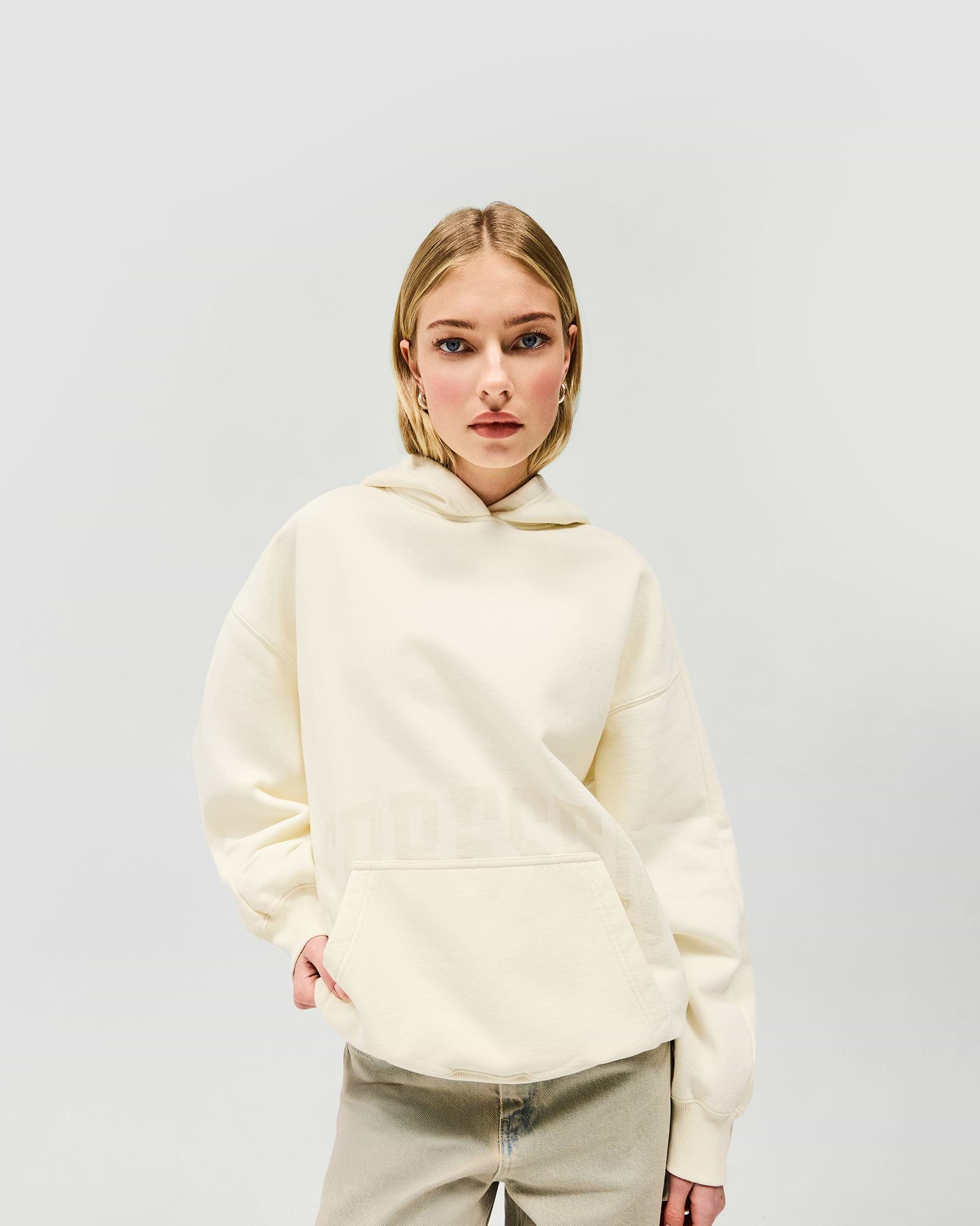 Woman wearing an oversized cream hoodie on a plain white background | Boyfriend Graphic Hoodie in Cream | Mid weight relaxed fit oversized hoodie | Womens SS25 Hoodies | Represent Clo