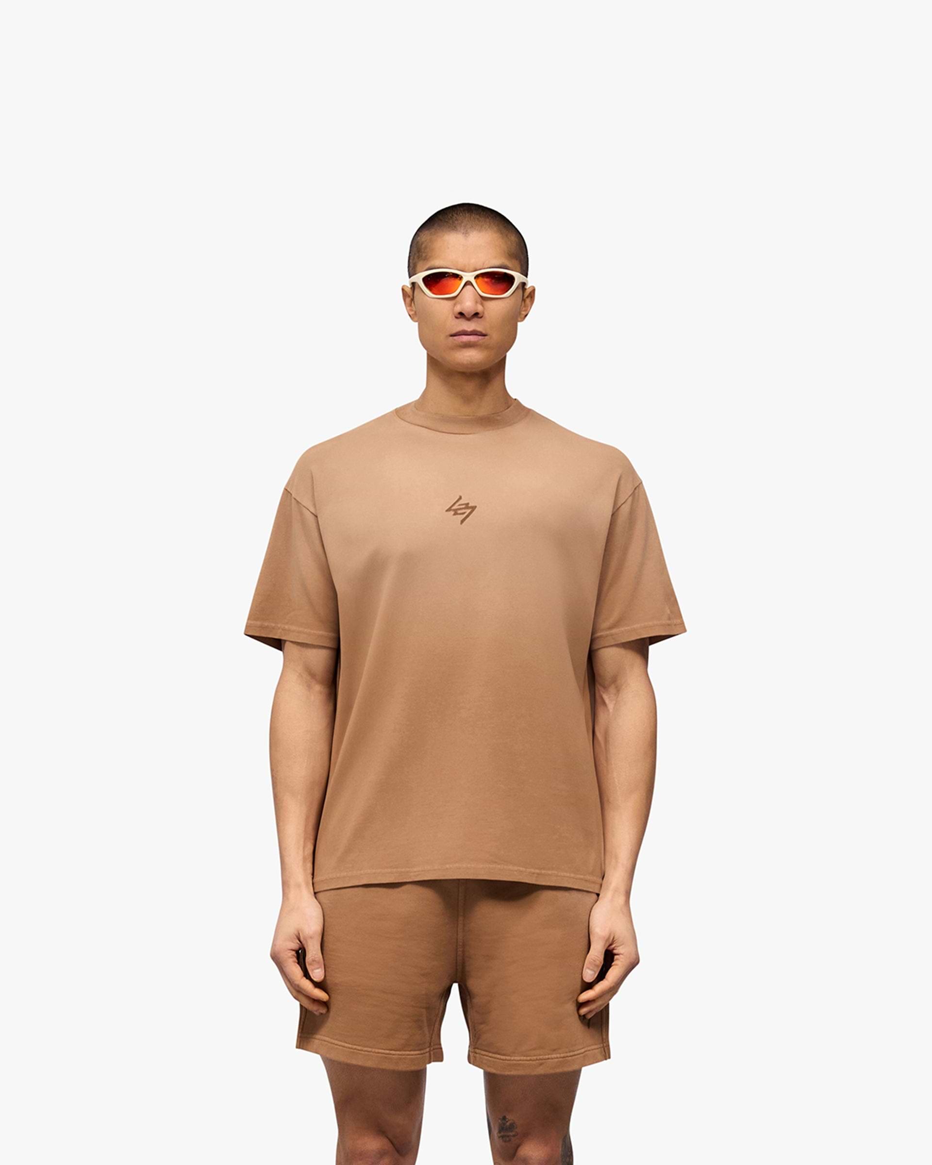 Man wearing a rust oversized t-shirt on a plain white background | 247 Motion Oversized T-Shirt in Rust | T-Shirt with stretch and graphic print | 247 T-Shirts | Represent Clo
