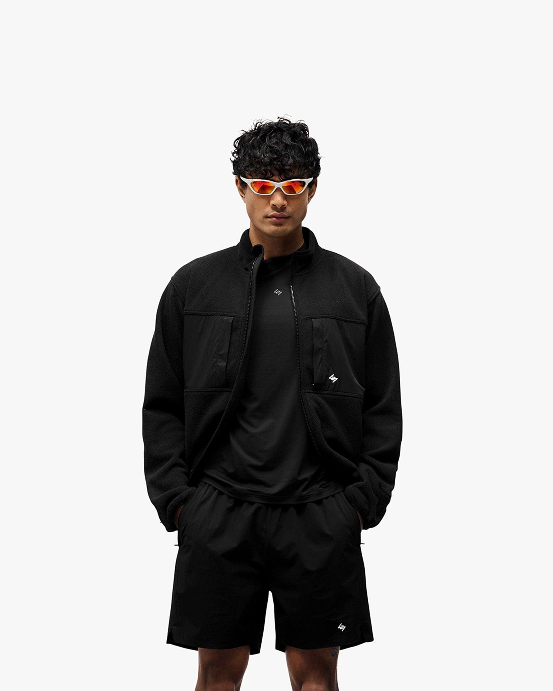 Man wearing a black fleece on a plain white background | 247 Polar Panelled Fleece in Black | Fleece with double-ended zip and toggle hem | 247 Outerwear | Represent Clo