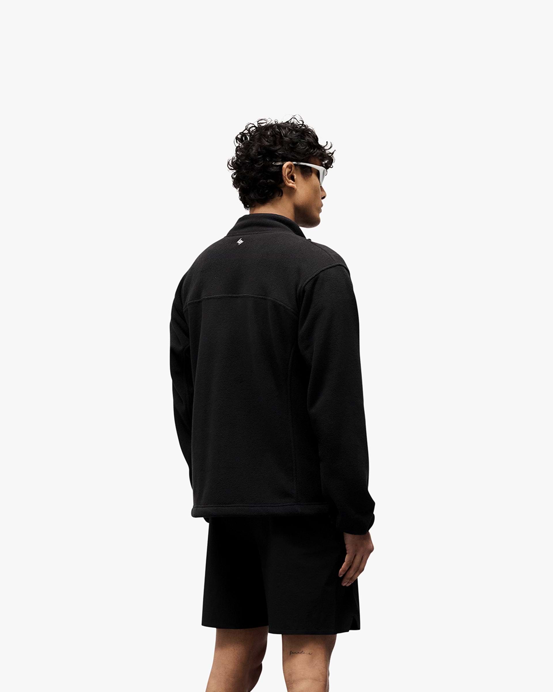Man wearing a black fleece on a plain white background | 247 Polar Panelled Fleece in Black | Fleece with zip pockets and toggle hem | 247 Outerwear | Represent Clo