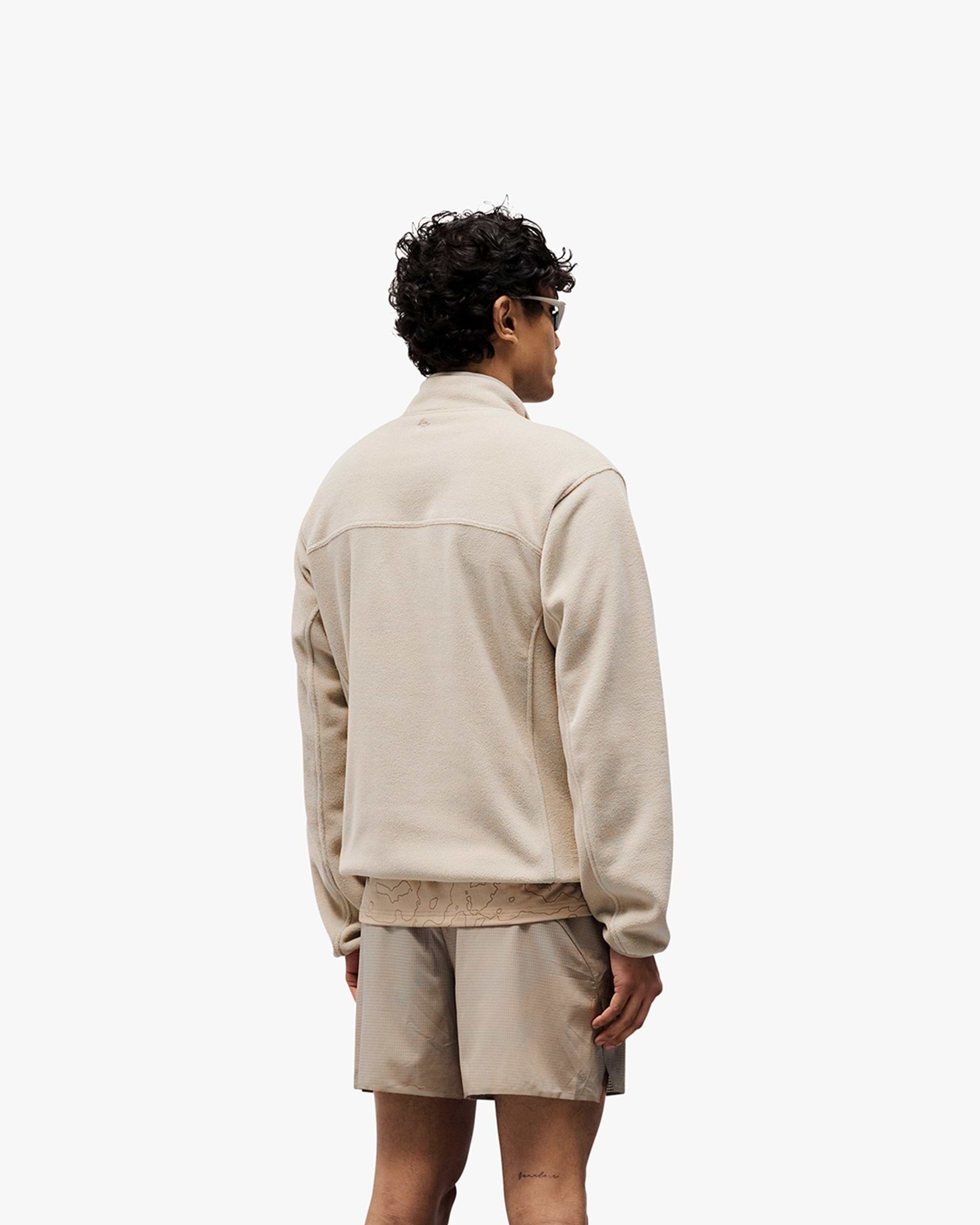 Man wearing a grey fleece on a plain white background | 247 Polar Panelled Fleece in Pebble | Fleece with zip pockets and toggle hem | 247 Outerwear | Represent Clo