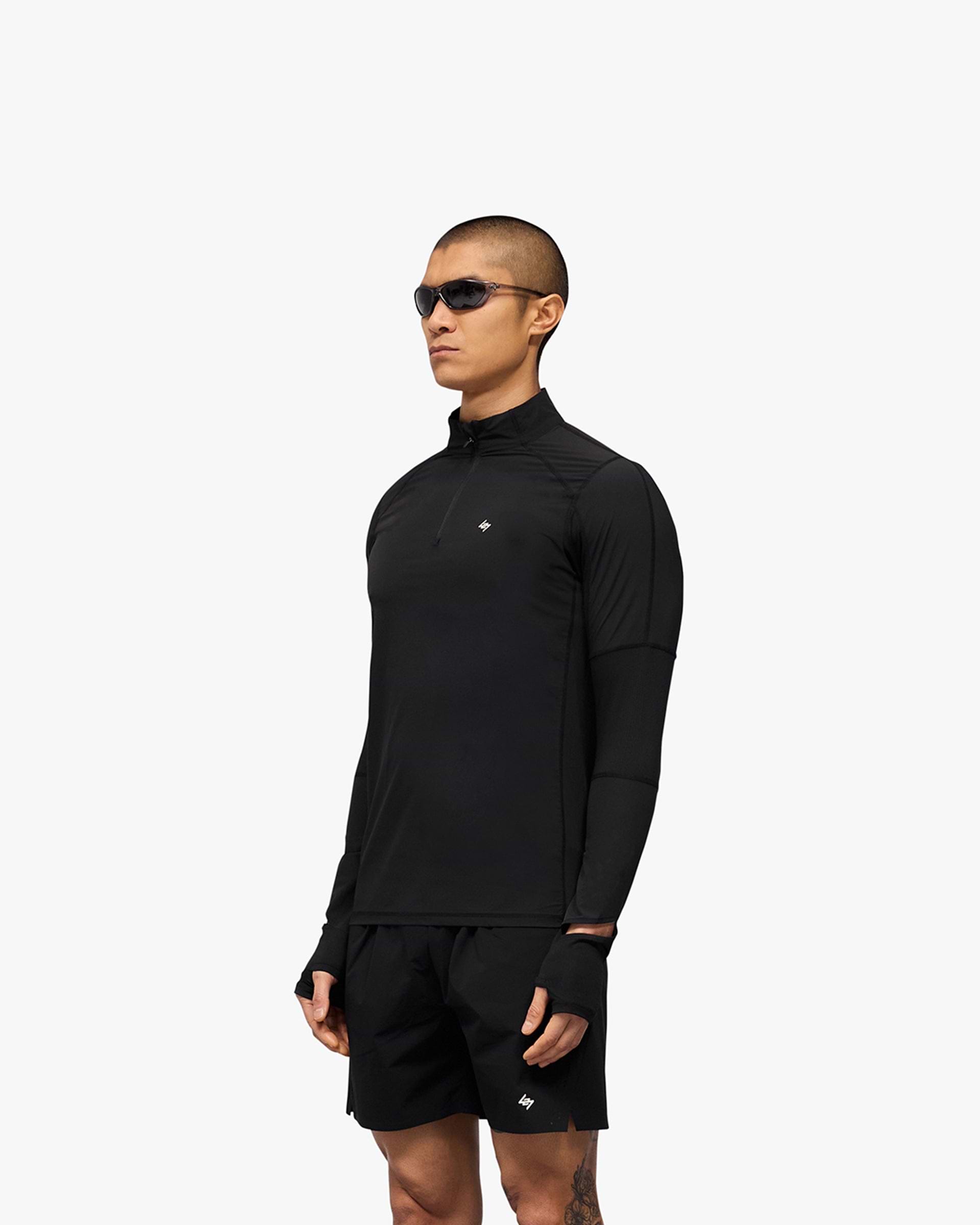 Man wearing a black quarter zip jacket on a plain white background | 247 Run Quarter Zip in Jet Black | Nylon blend outerwear with mesh panels | 247 Outerwear | Represent Clo