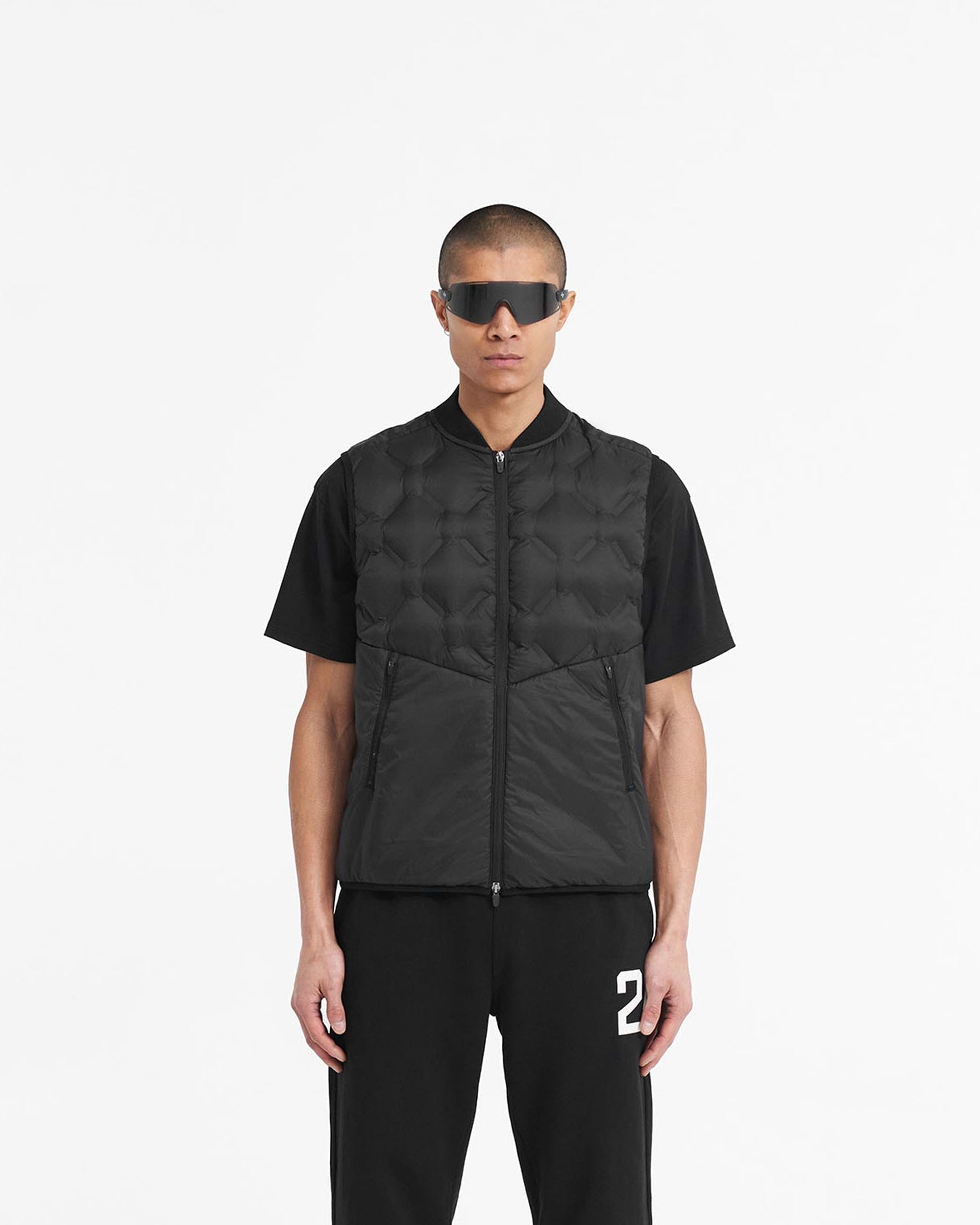 Man wearing a black gilet on a plain white background | 247 Lightweight Gilet in Black | Nylon gilet with bomber collar and mesh ventilation | 247 Outerwear | Represent Clo