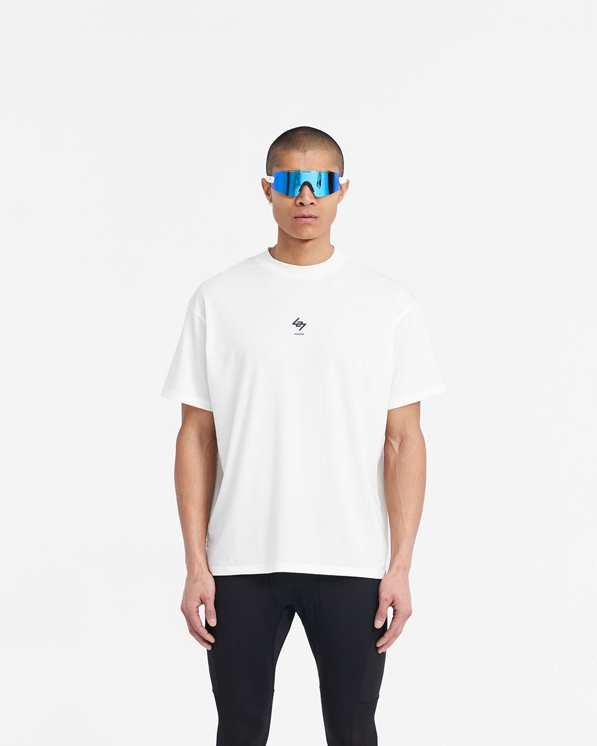 Man wearing an oversized white t-shirt on a plain white background | 247 Oversized T-Shirt in Flat White | Quick dry lightweight gym top | 247 T-Shirts | Represent Clo