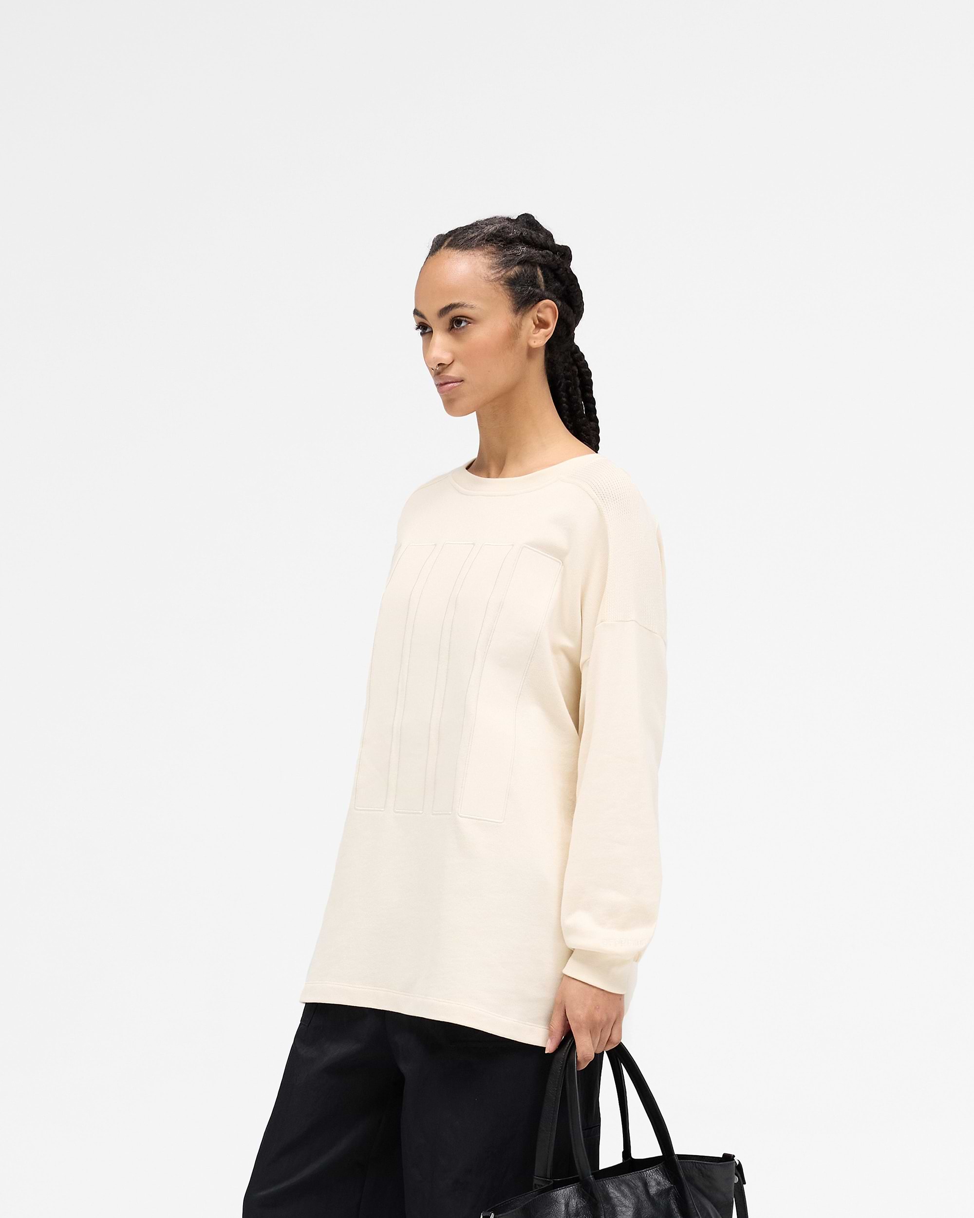 Back product image of a womens cream long sleeve top on a plain white background | Overdrive Long Sleeve Top in Cream | Oversized fit brushed cotton top | SS25 Tops | Represent Clo