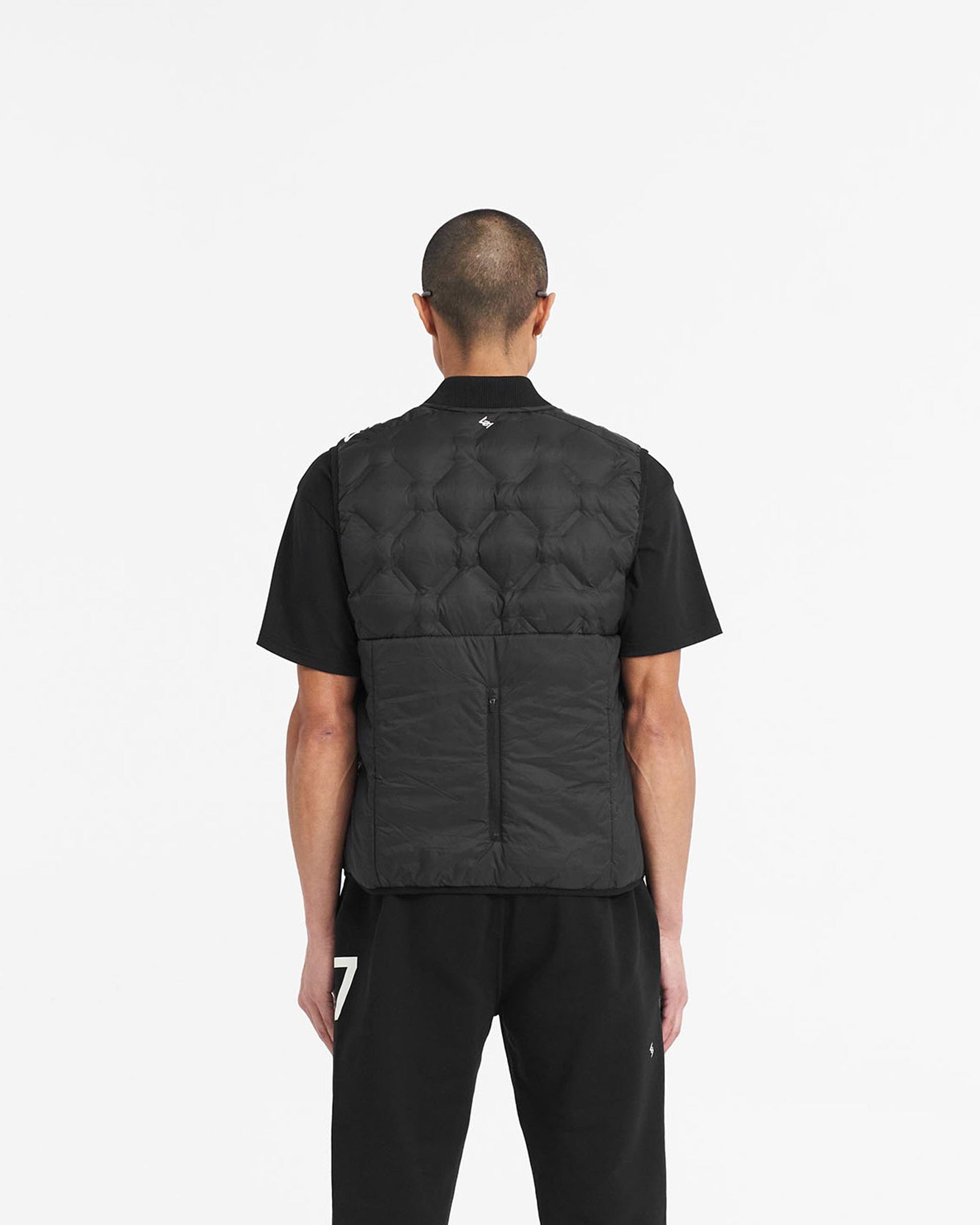 Man wearing a black gilet on a plain white background | 247 Lightweight Gilet in Black | Gilet with feather down fill and bomber collar | 247 Outerwear | Represent Clo