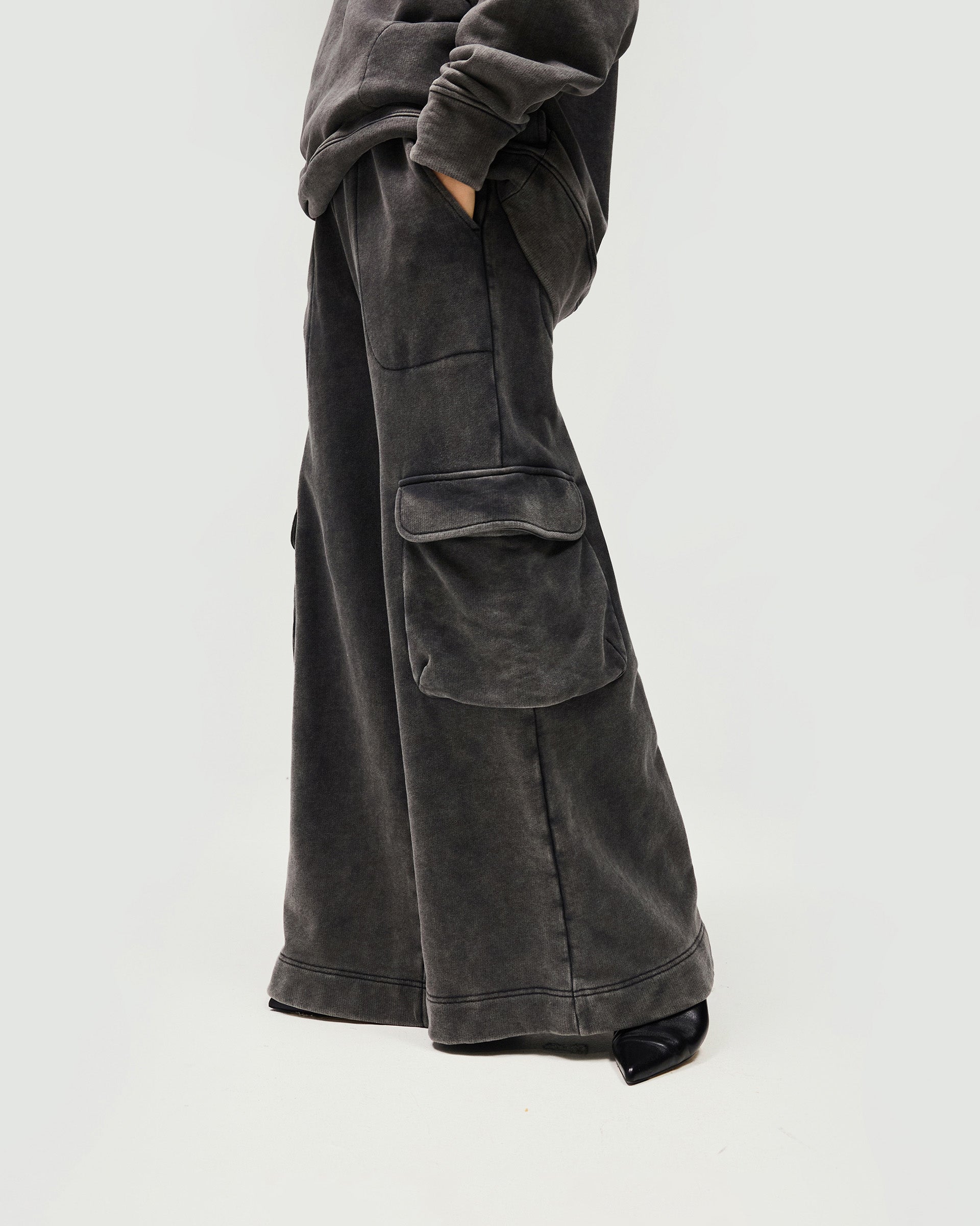 Woman wearing oversized grey sweatpants on a plain white background | Monster Sweatpant in Charcoal | Sweatpants with elasticated waist and oversized pockets | Womens SS25 Bottoms | Represent Clo