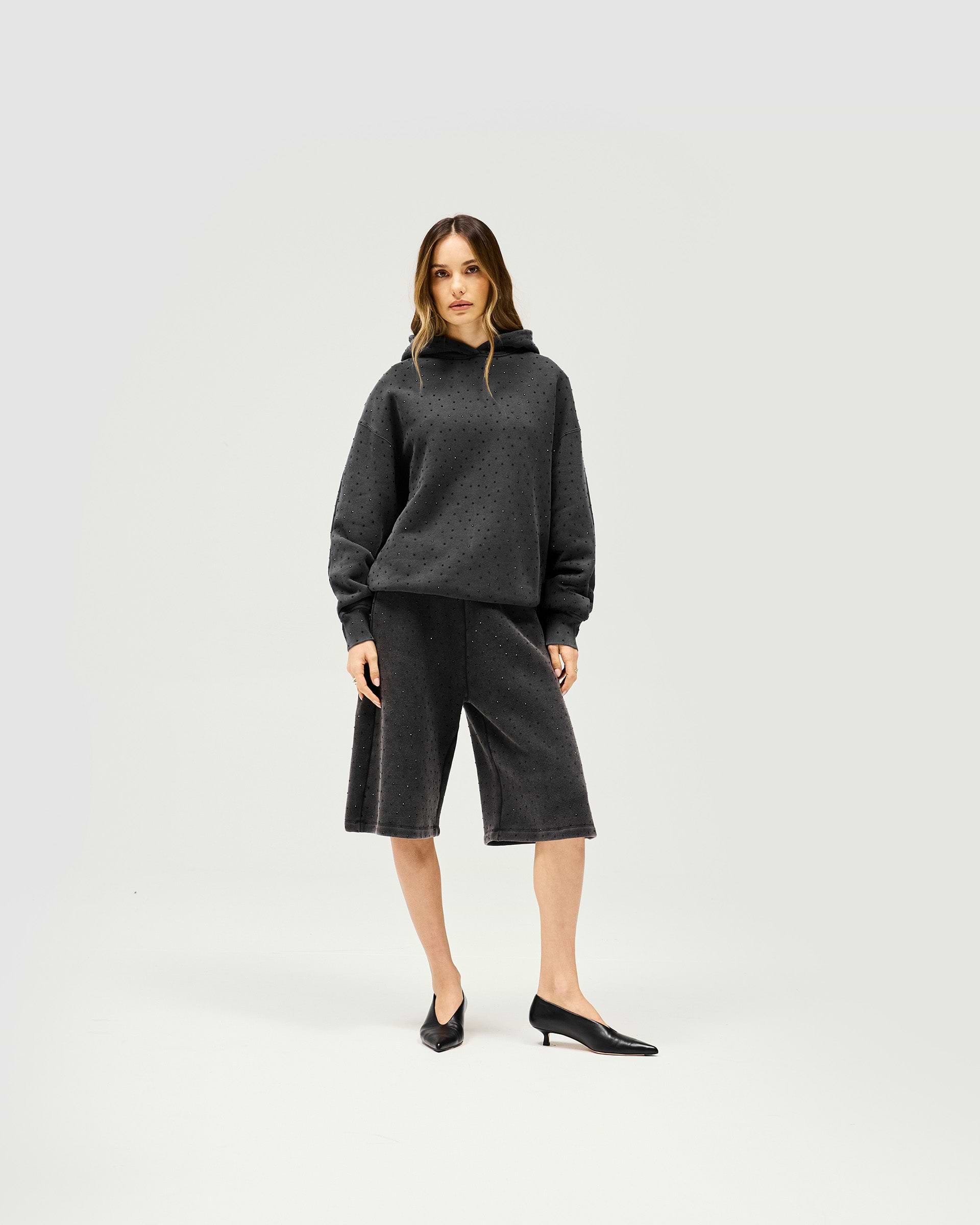 Woman wearing grey leather Bermuda shorts on a plain white background | Spark Shorts in Washed Grey | Leather shorts with elasticated waist | Womens SS25 Shorts | Represent Clo