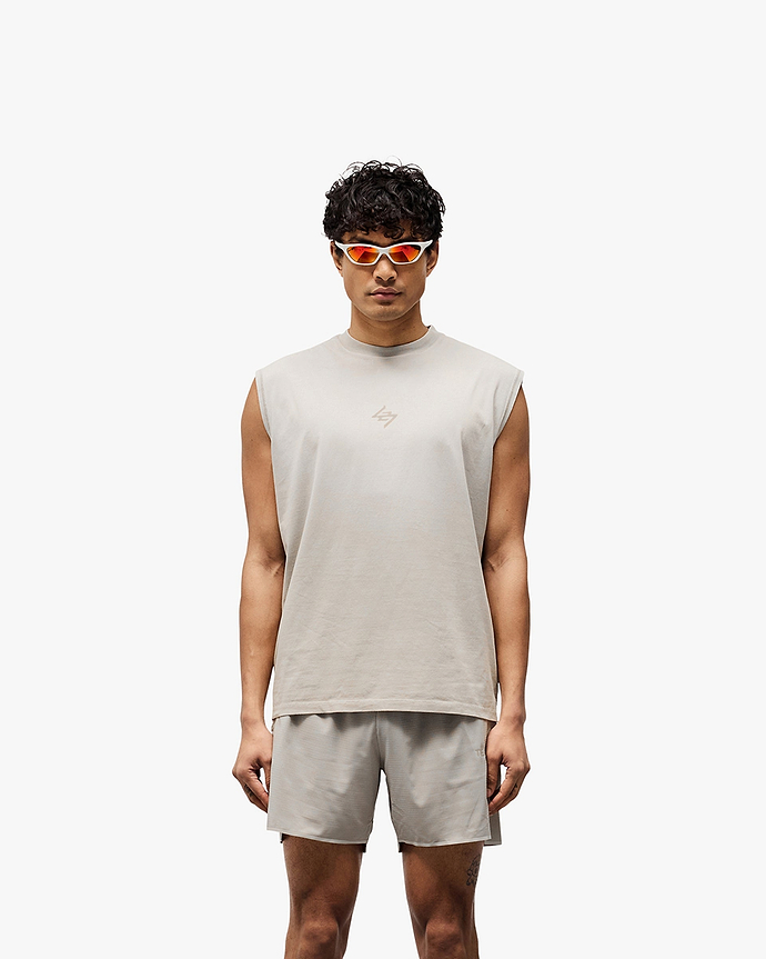 Man wearing a grey oversized tank on a plain white background | 247 Motion Oversized Tank in Pebble | Oversized tank with 2 way stretch and water based graphic print | 247 T-Shirts | Represent Clo