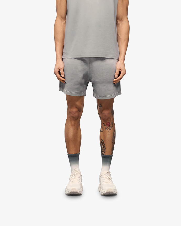 Man wearing grey shorts on a plain white background | 247 Motion Shorts in Titanium | Jersey shorts with elasticated waistband and drawcord | 247 Shorts | Represent Clo