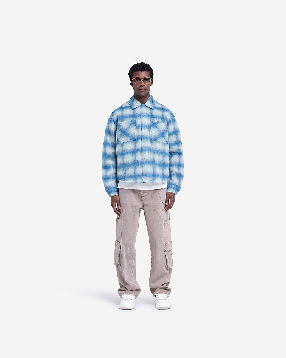 Man wearing an electric blue overshirt on a plain white background | Textured Overshirt in Electric Blue | Overshirt with patch pockets and popper closures | FW24 Shirts | Represent Clo