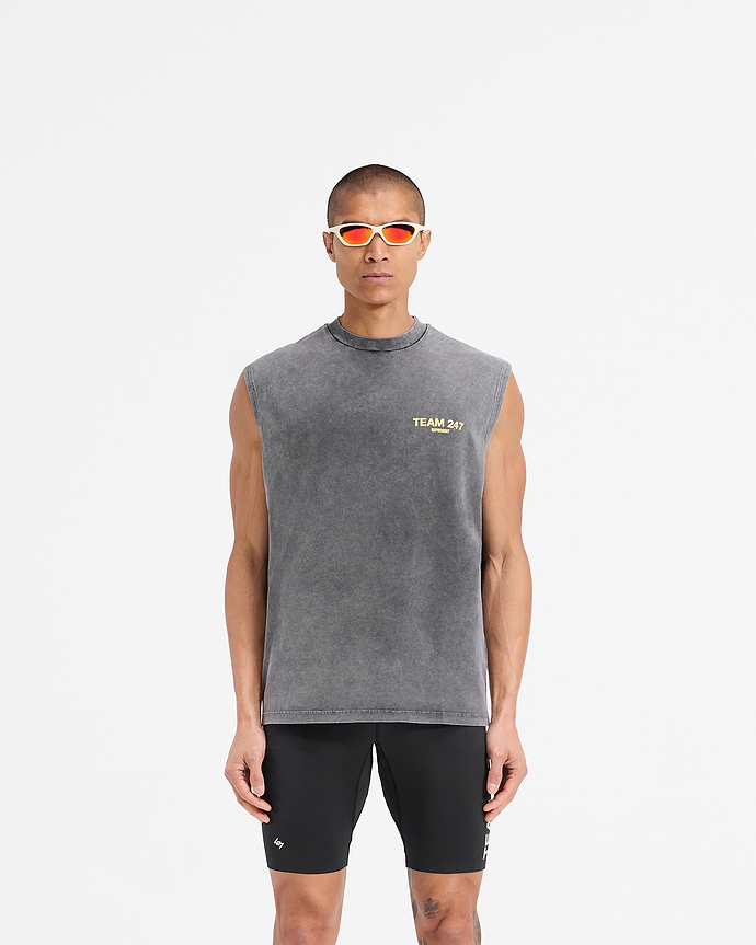 Man wearing an oversized grey tank top with yellow detailing on a plain white background | Team 247 Oversized Tank in Pewter Lemon | Oversized tank top with breathable quick-drying fabric | 247 T-Shirts | Represent Clo