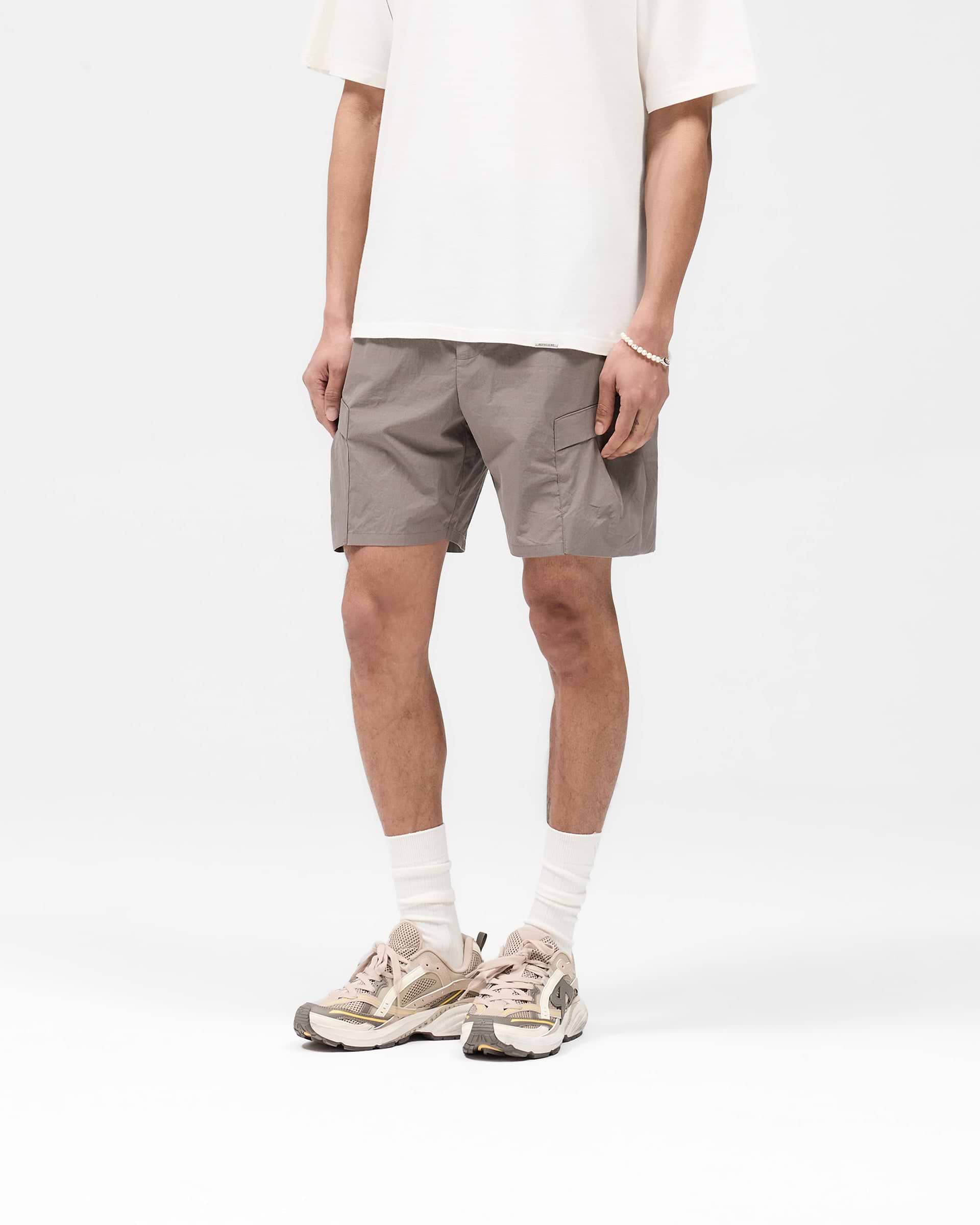 Back product image of mens grey cargo shorts on a plain white background | Tech Cargo Short in Mid Grey | Cargo shorts with hybrid-style waistband and pleated pockets | SS25 Shorts | Represent Clo