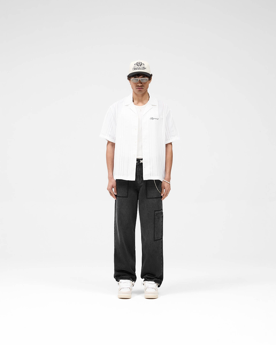Man wearing an antique white shirt on a plain white background | Embroidered Bowling Shirt in Antique White | Lightweight sheer bowling shirt with button-down front | SS25 Shirts | Represent Clo