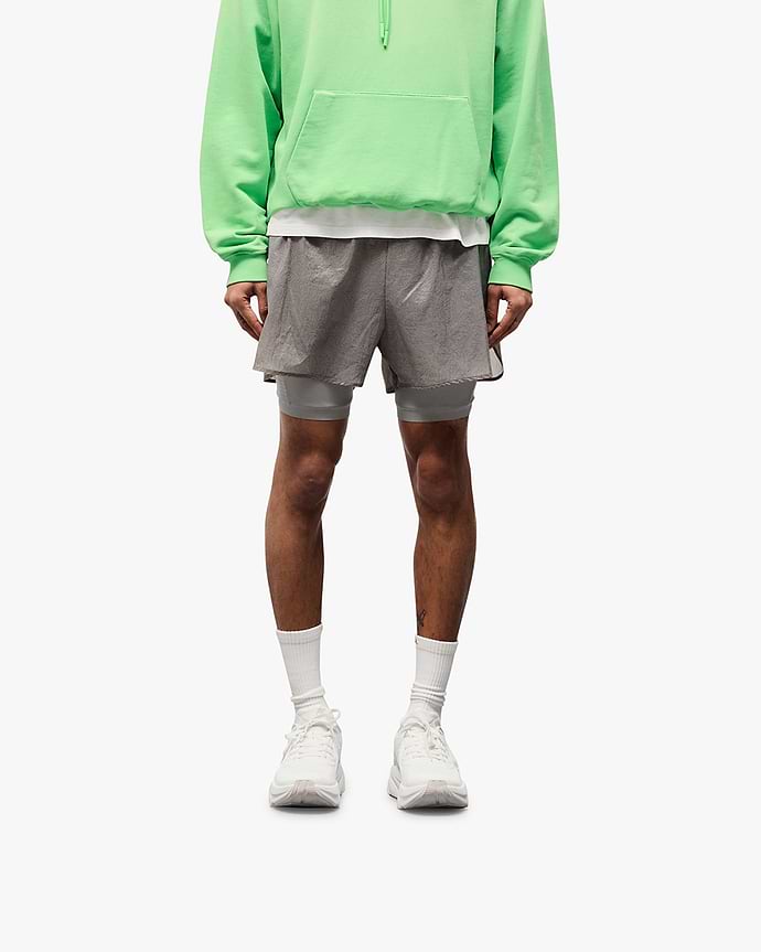 Man wearing grey 2-in-1 run shorts on a plain white background | 247 Contour 2-In-1 Run Shorts in Titanium | Shorts with inner legging and contour print | 247 Shorts | Represent Clo