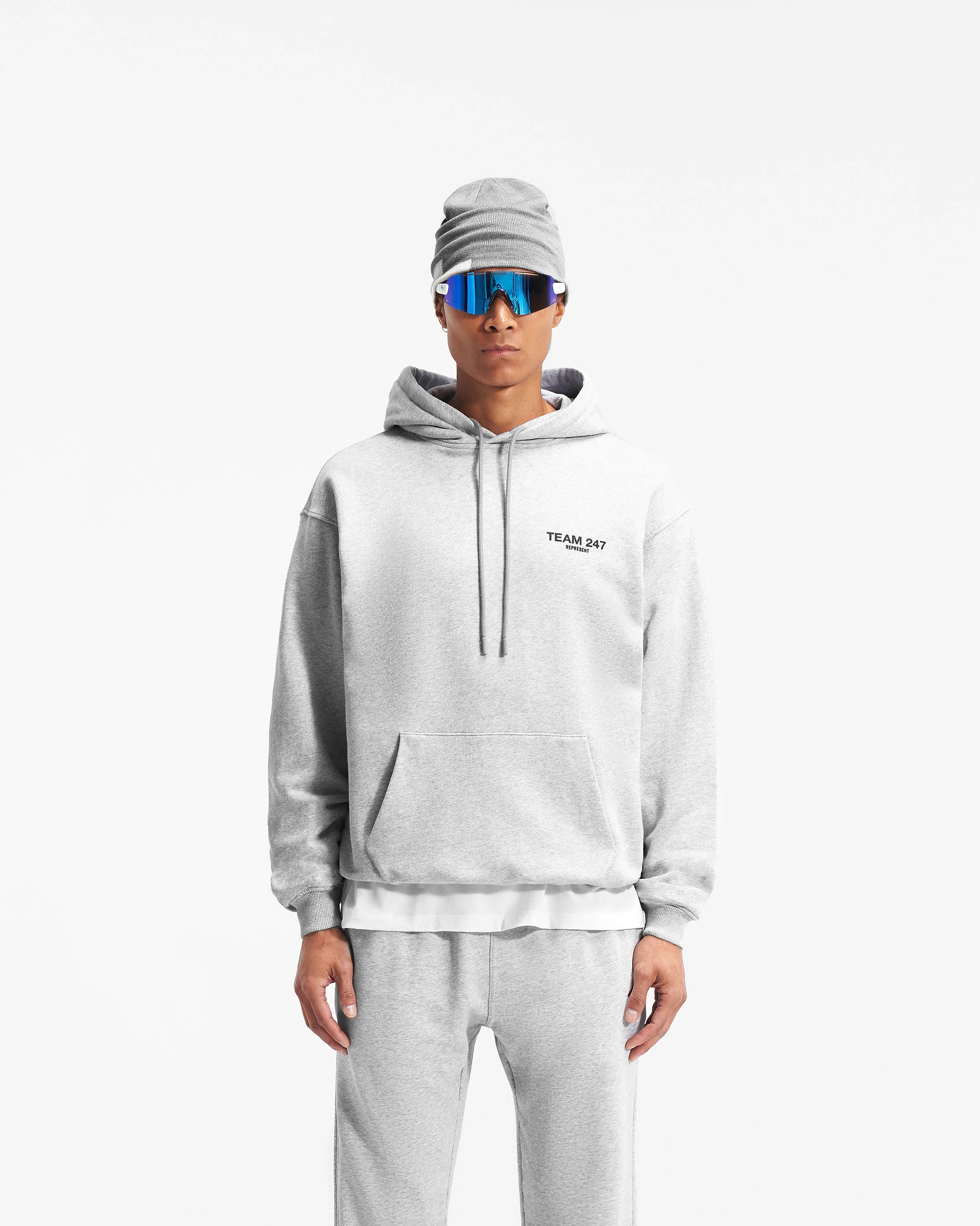 Man wearing an oversized grey hoodie on a plain white background | Team 247 Oversized Hoodie in Ash Grey | Oversized fit hoodie with ribbed cuffs and hem | 247 Hoodies | Represent Clo