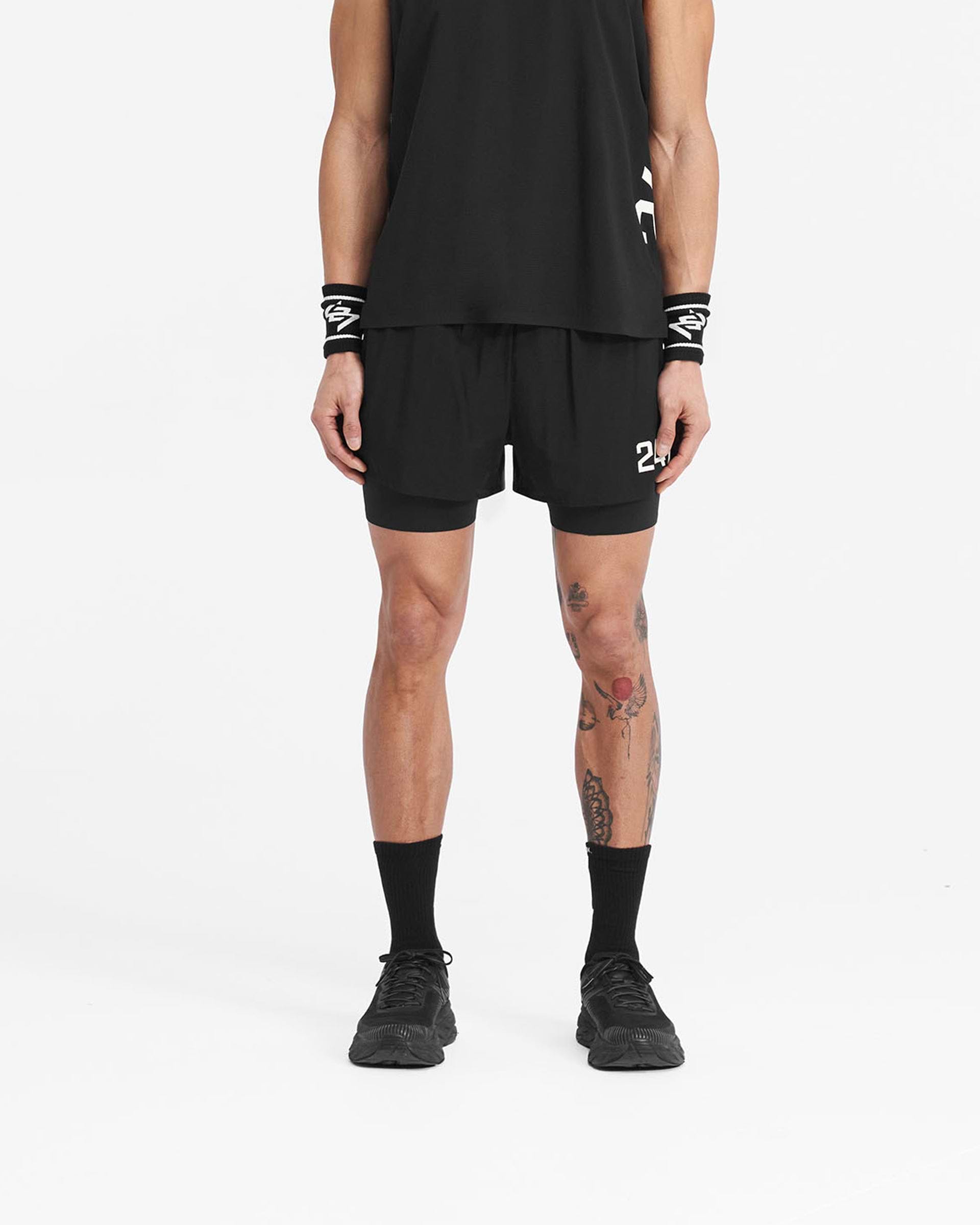 Man wearing black shorts on a plain white background | 247 Trail Short in Jet Black | 2-in-1 shorts with 4-way stretch and zip pockets | 247 Shorts | Represent Clo