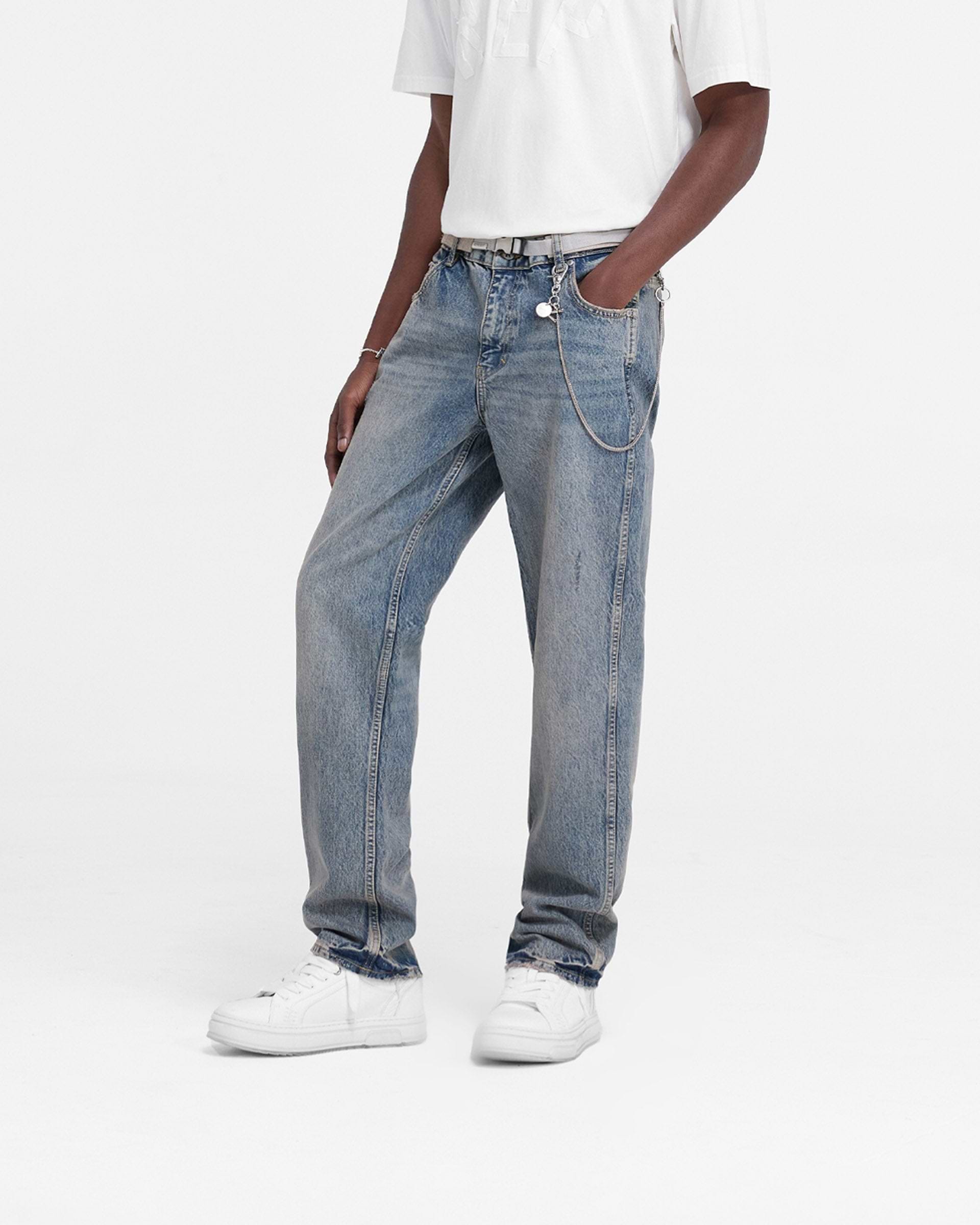 Man wearing straight leg blue denim jeans on a plain white background | R2 Straight Leg Denim in Mid Blue | Jeans with embroidered initial | FW24 Denim | Represent Clo