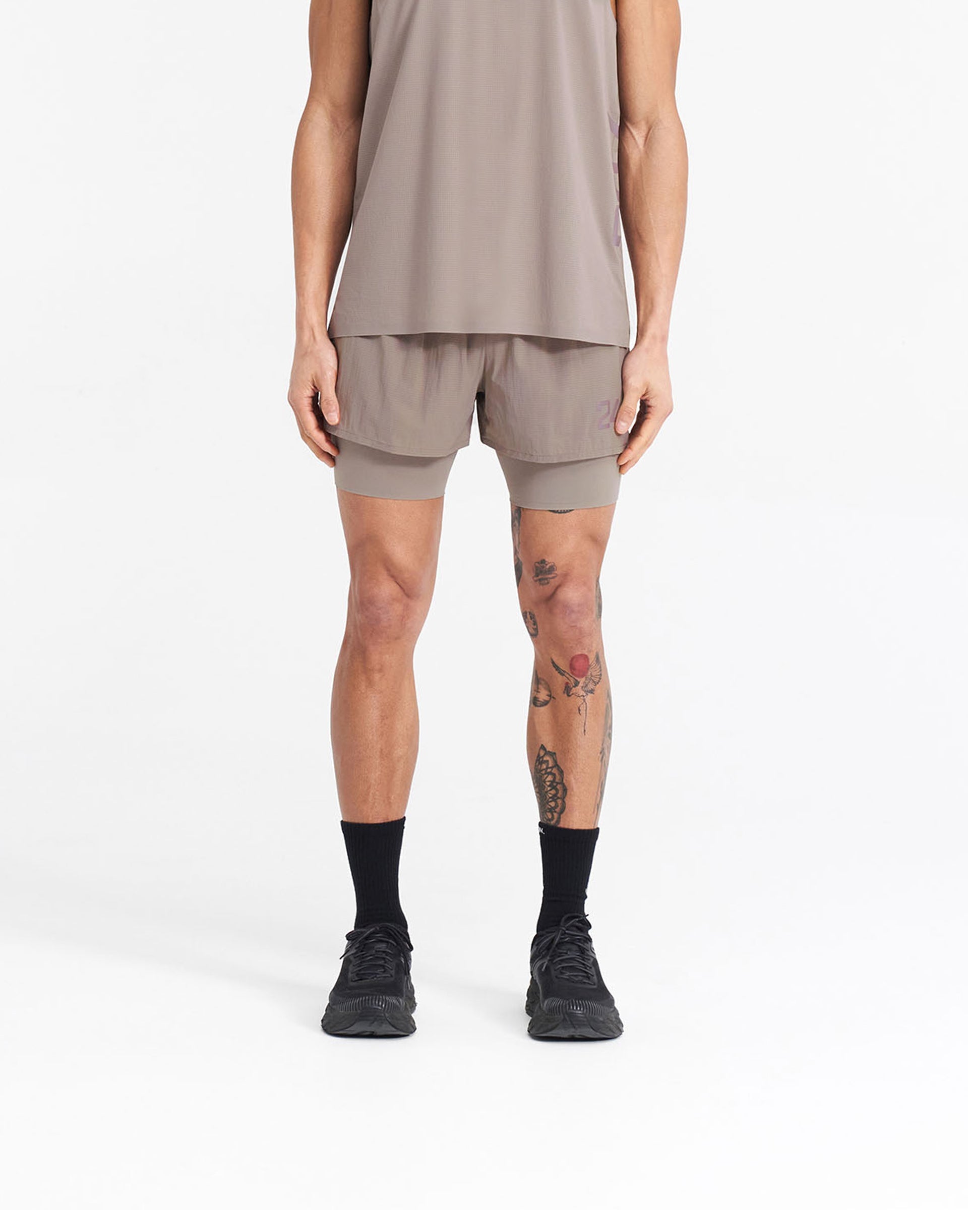 Man wearing grey 2-in-1 trail shorts on a plain white background | 247 Trail Short in Cinder | Shorts with 4-way stretch and internal tight | 247 Shorts | Represent Clo