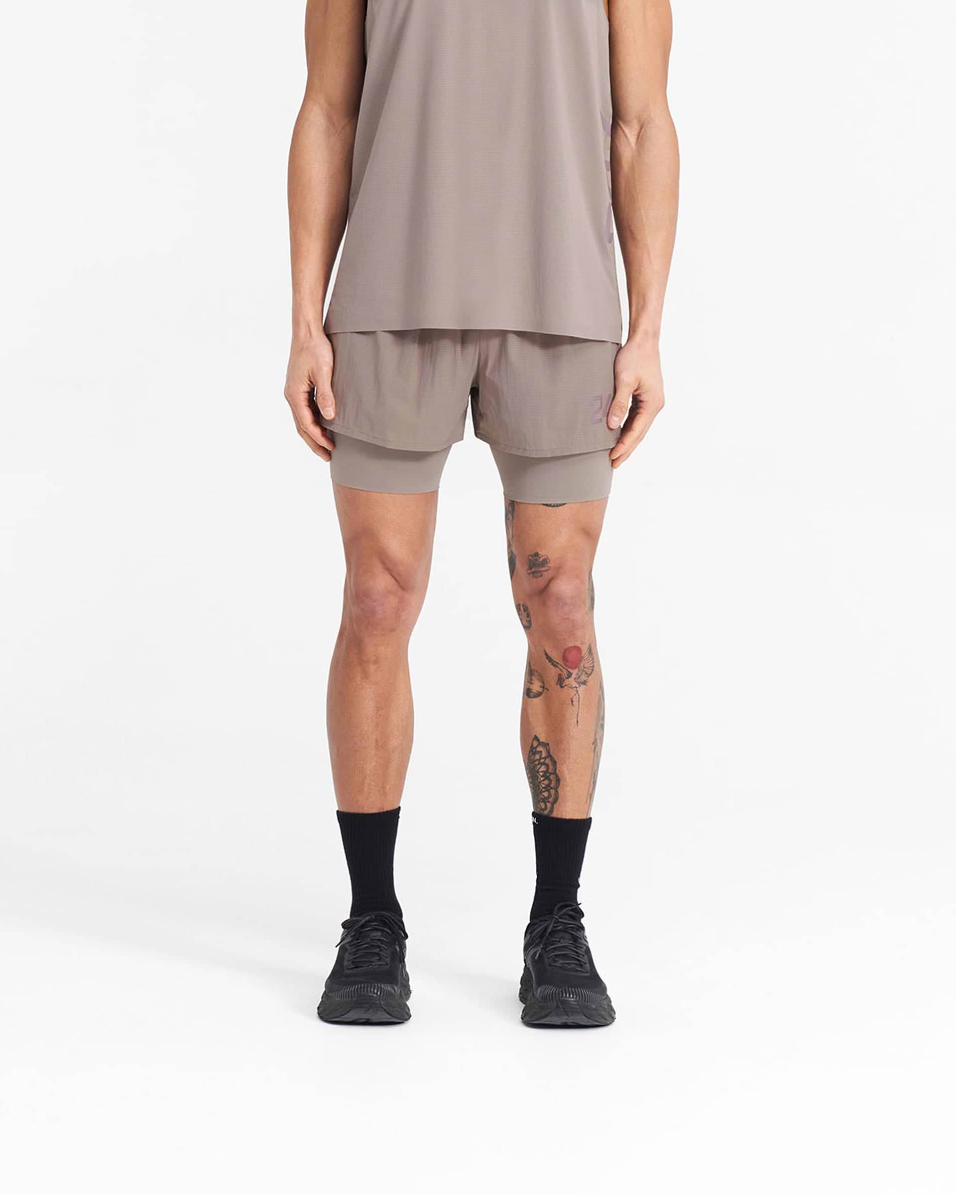 Man wearing grey 2-in-1 trail shorts on a plain white background | 247 Trail Short in Cinder | Shorts with 4-way stretch and internal tight | 247 Shorts | Represent Clo
