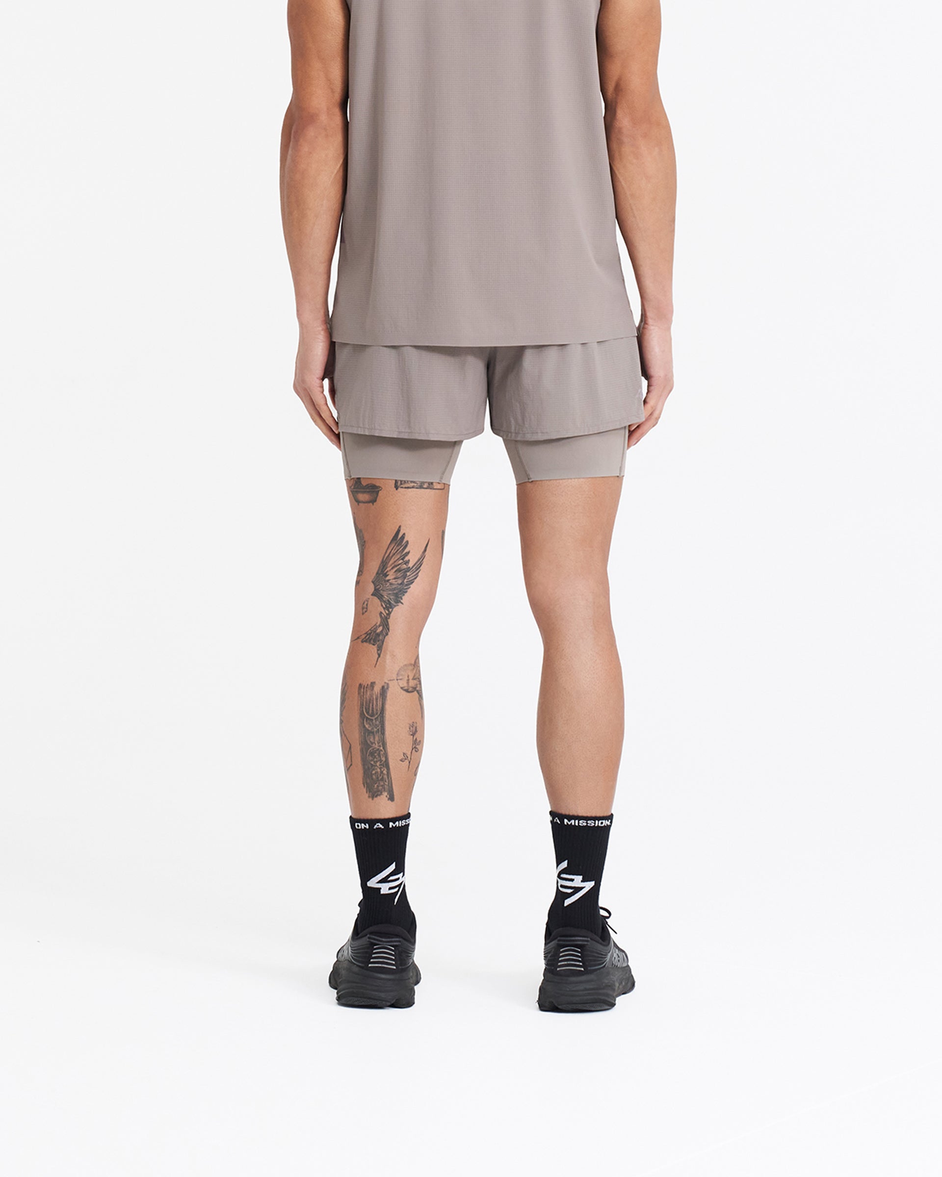 Man wearing grey 2-in-1 shorts on a plain white background | 247 Trail Short in Cinder | Stretch ripstop with internal tights and zip pockets | 247 Shorts | Represent Clo