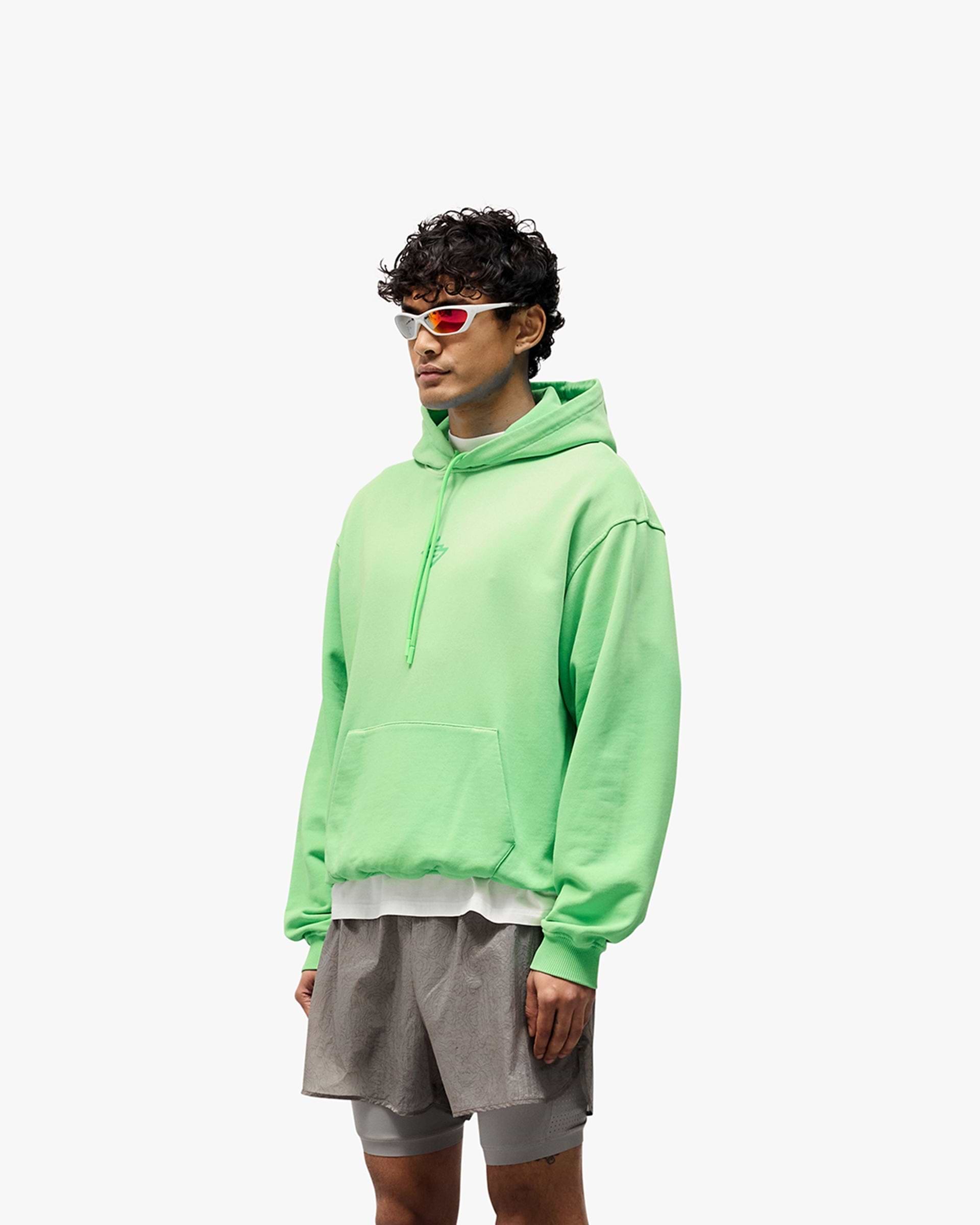 Man wearing an oversized green hoodie on a plain white background | 247 Motion Oversized Hoodie in Speed Green | Oversized hoodie with ribbed hem and cuffs | 247 Hoodies | Represent Clo