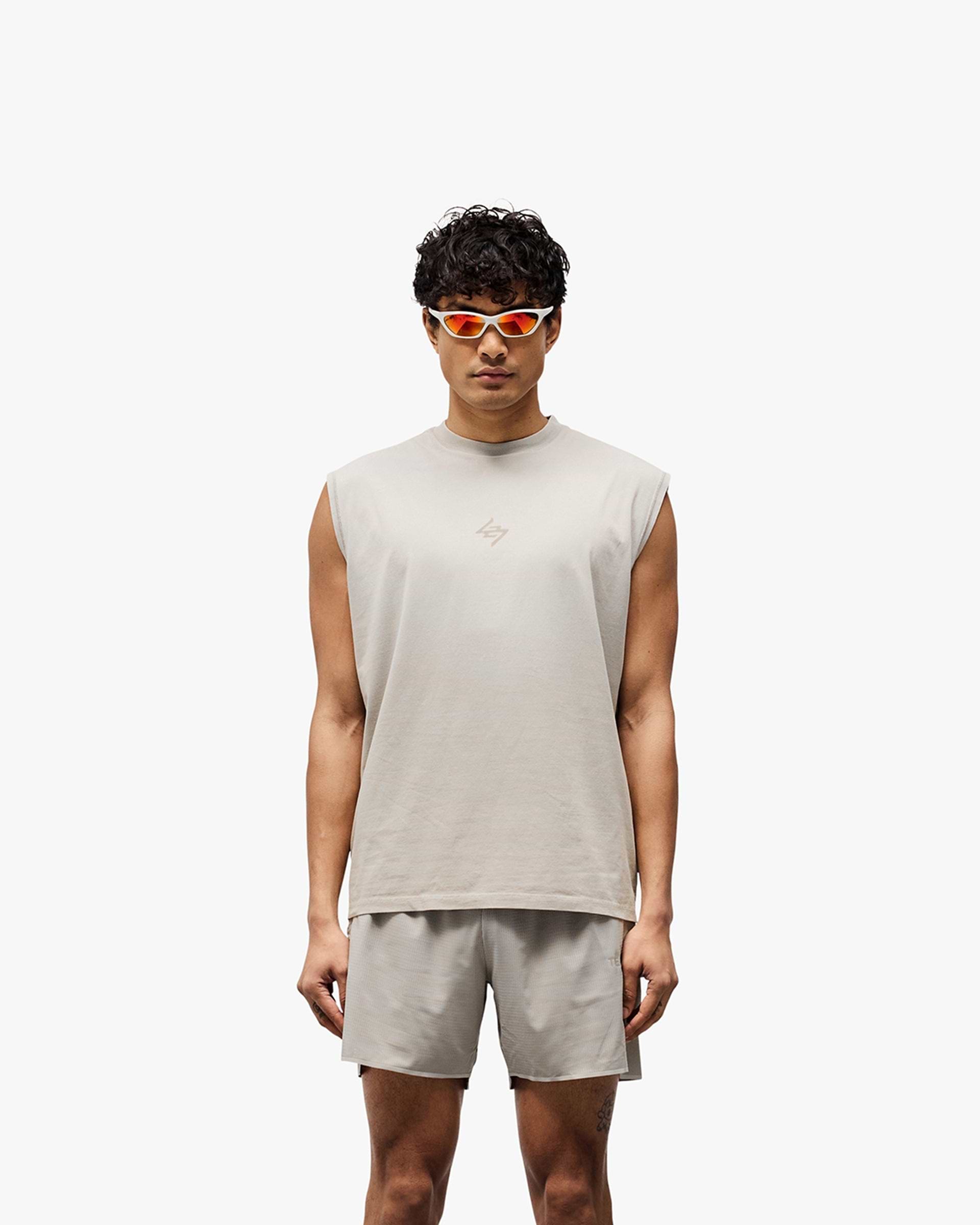 Man wearing a grey oversized tank on a plain white background | 247 Motion Oversized Tank in Pebble | Oversized tank with 2 way stretch and water based graphic print | 247 T-Shirts | Represent Clo
