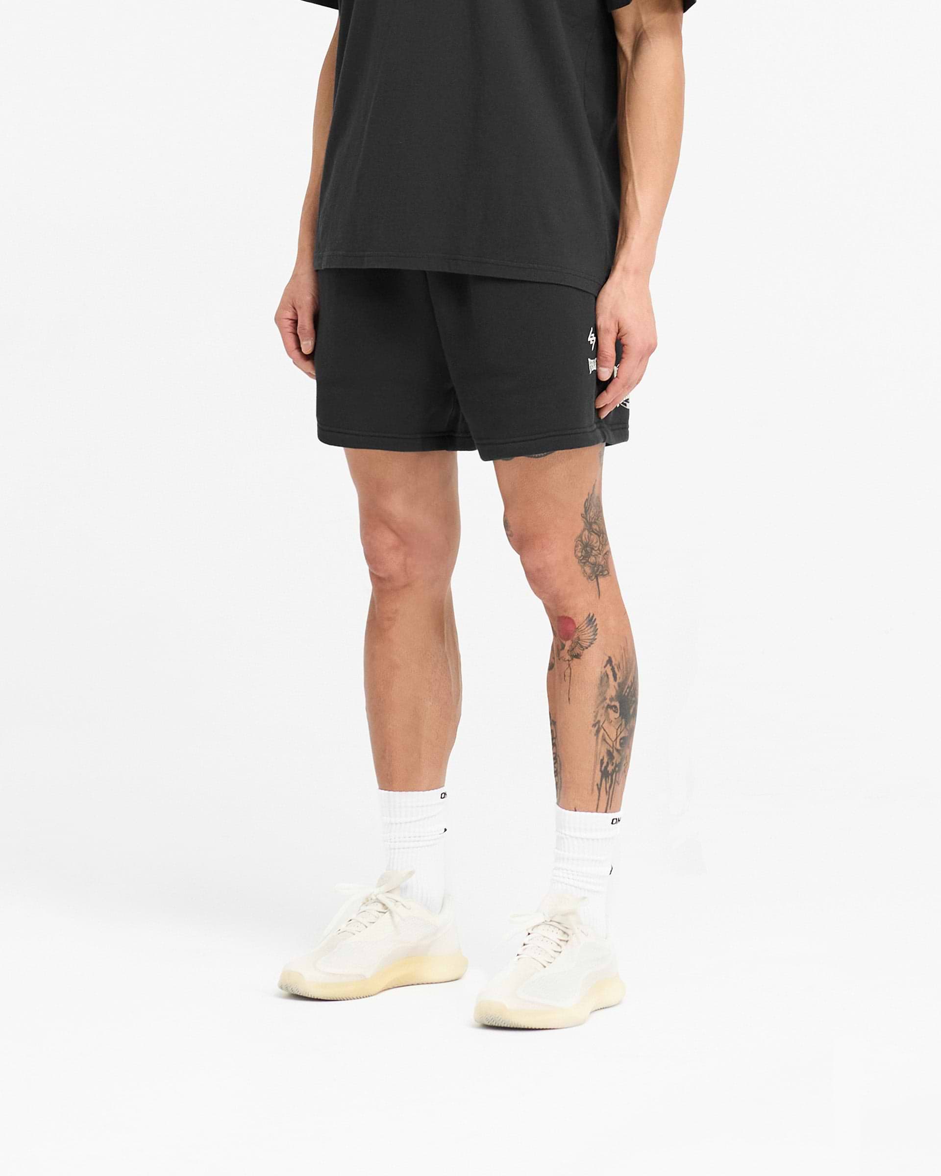 Man wearing off-black jersey shorts on a plain white background | 247 X Everlast Training Camp Jersey Shorts in Off Black | Boxy fit shorts with elasticated waistband | 247 Shorts | Represent Clo