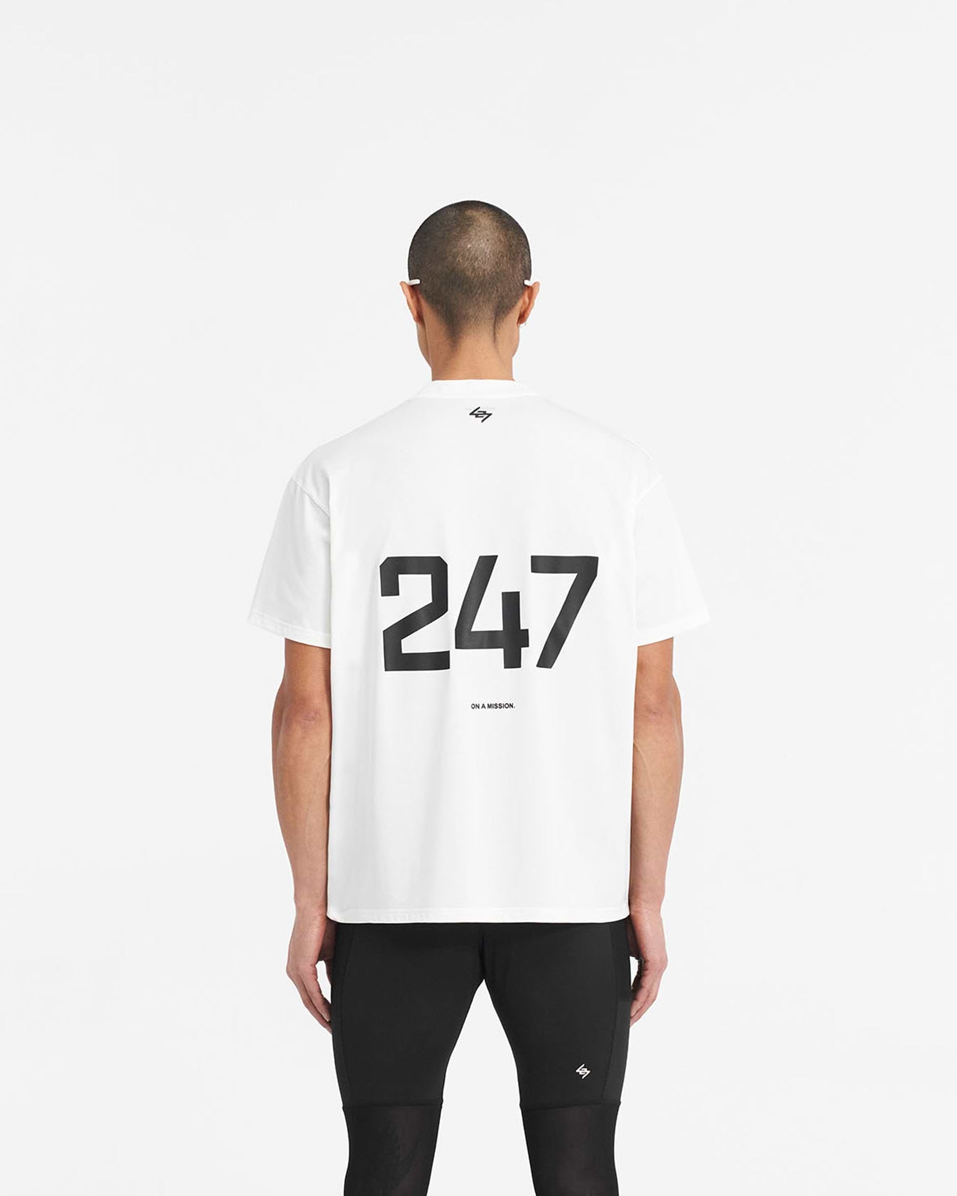 Man wearing an oversized white t-shirt on a plain white background | 247 Oversized T-Shirt in Flat White | Quick dry gym t-shirt with 4-way stretch | 247 T-Shirts | Represent Clo