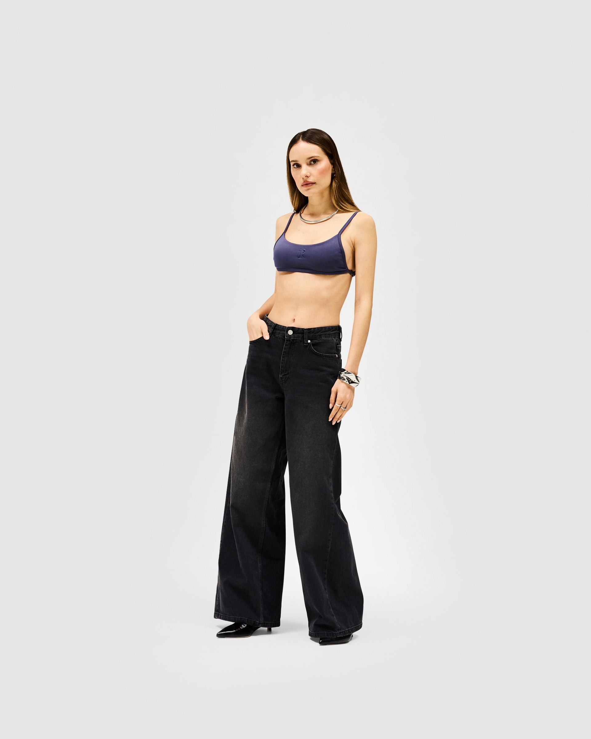 Woman wearing a grey bralette on a plain white background | Control Bralette in Graphite | Bib front bralette in compact neoprene | Womens SS25 Tops | Represent Clo