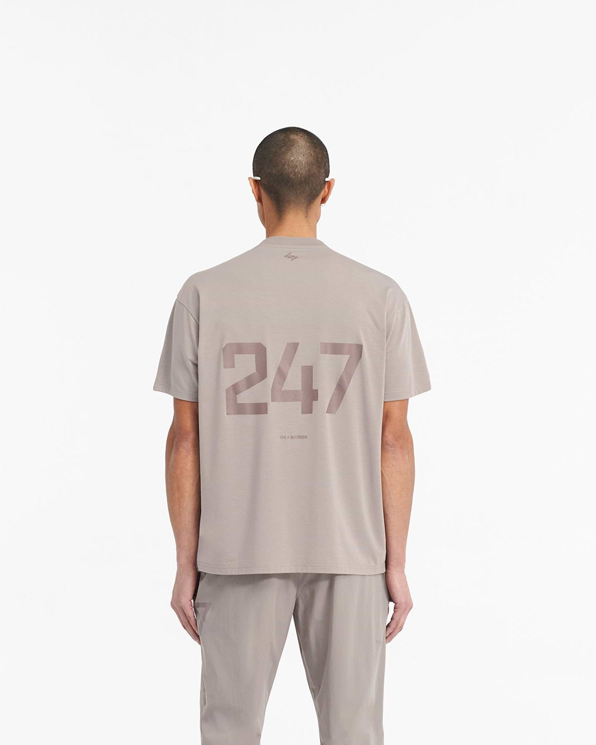 Man wearing a grey oversized t-shirt on a plain white background | 247 Oversized T-Shirt in Cinder | Quick dry lightweight gym t-shirt | 247 T-Shirts | Represent Clo