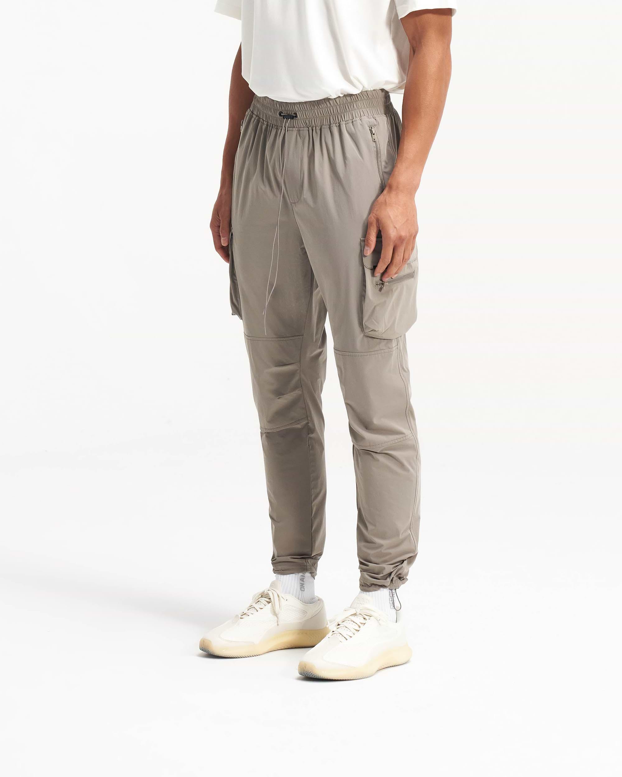 Back product image of mens taupe pants on a plain white background | 247 Pant in Taupe | Cargo pants with technical 4-way stretch and cargo pockets | 247 Pants | Represent Clo
