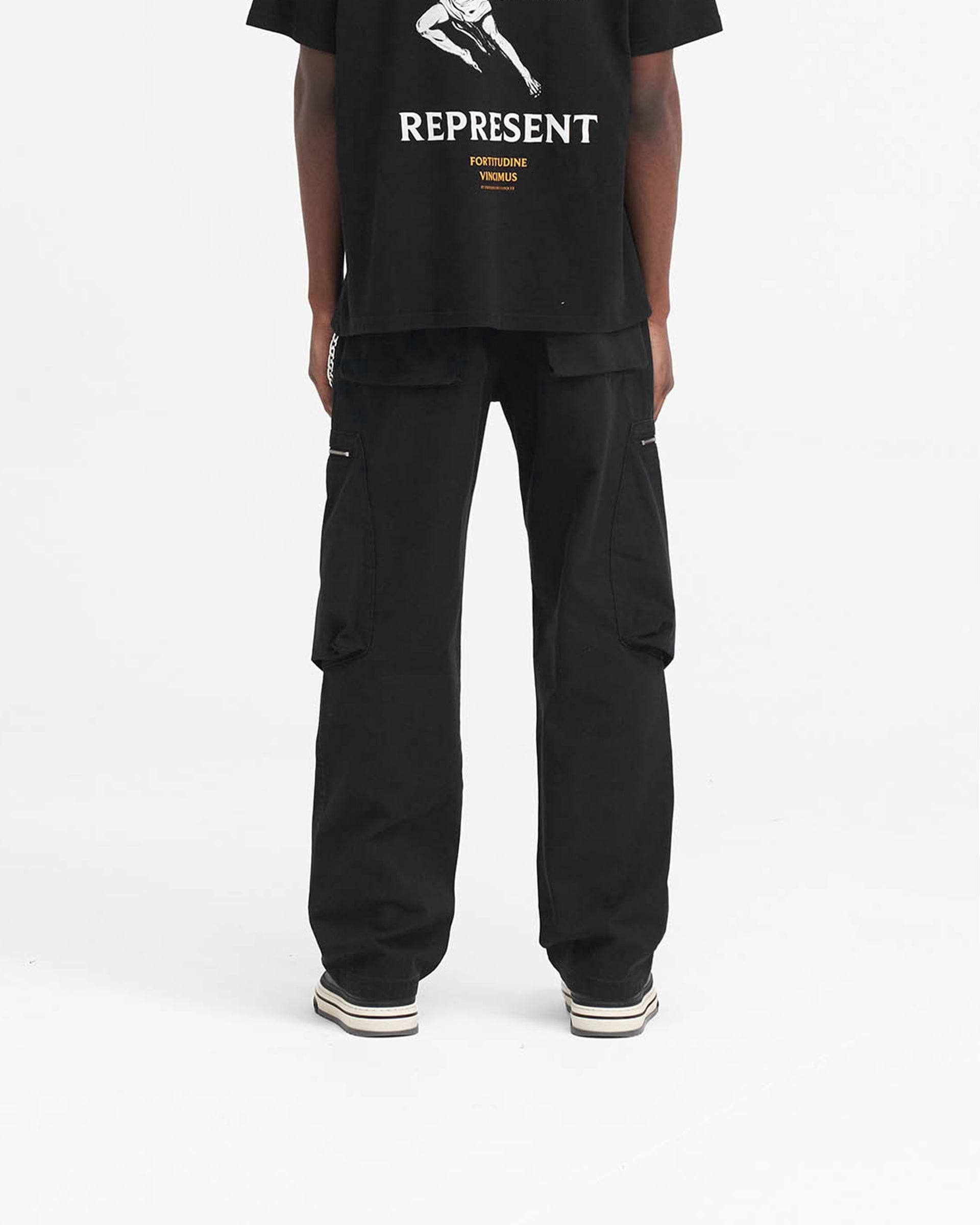 Man wearing black pants on a plain white background | Workshop Pant in Black | Oversized fit pants with asymmetric angled thigh pockets | SS24 Pants | Represent Clo