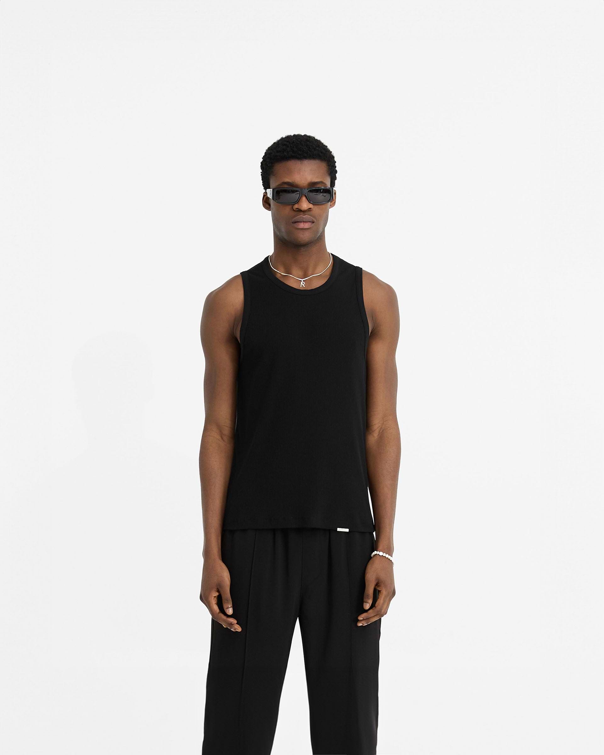 Man wearing a black rib vest on a plain white background | Initial Rib Vest in Black | Vest with embroidered initial and metal bar | Initial T-Shirts | Represent Clo