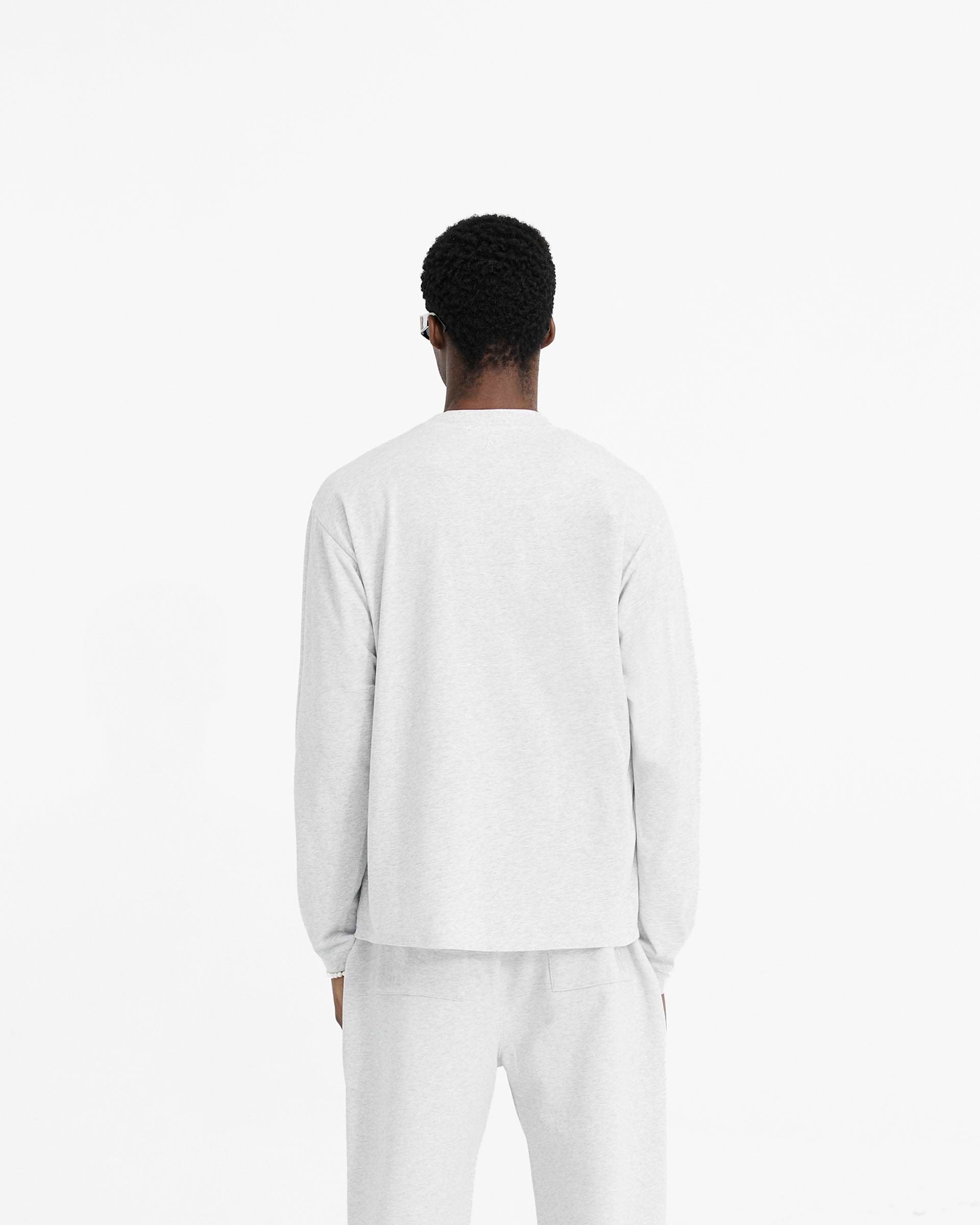 Man wearing a grey long sleeve t-shirt on a plain white background | Initial Long Sleeve T-Shirt in Ice Grey Marl | Regular fit T-Shirt with embroidered Initial and metal bar logo | Initial T-Shirts | Represent Clo