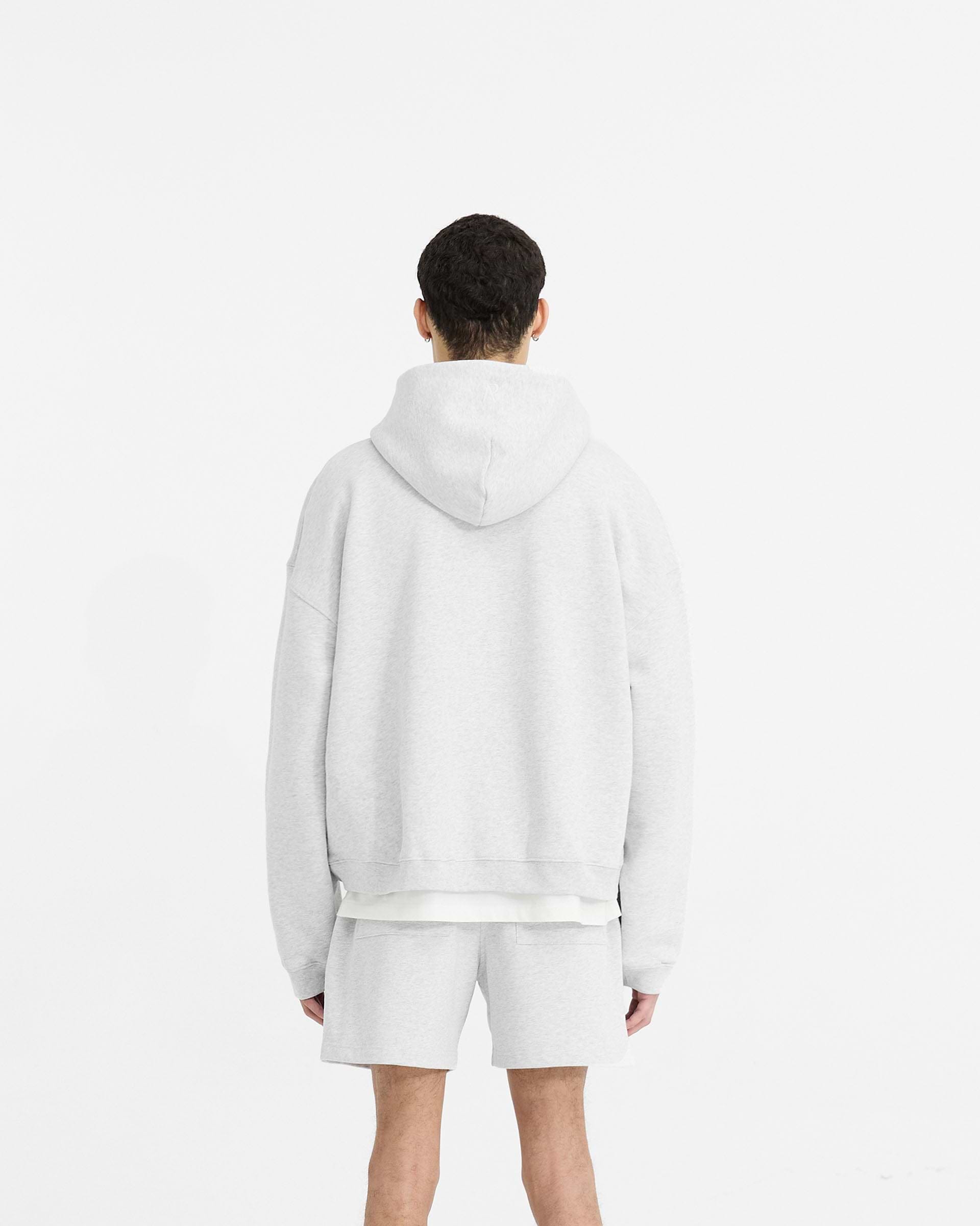 Man wearing a grey zip hoodie on a plain white background | Initial Boxy Zip Through Hoodie in Ice Grey Marl | Oversized boxy fit cropped hoodie | Initial Hoodies | Represent Clo