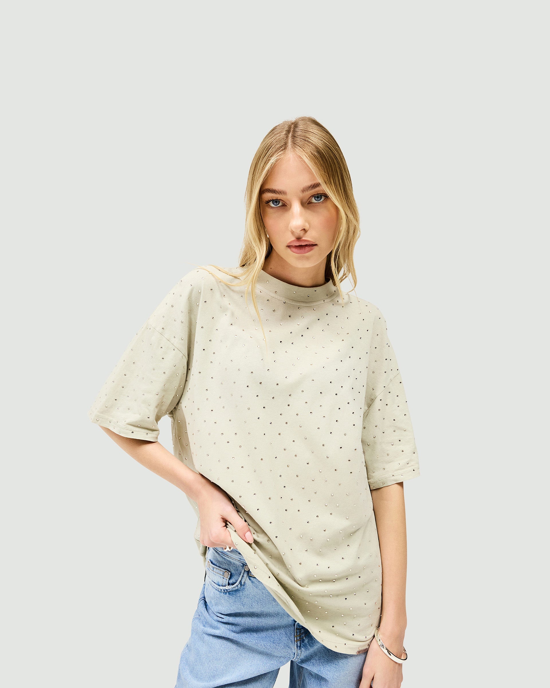 Woman wearing an oversized grey t-shirt on a plain white background | Spark T-Shirt in Storm | Soft acid wash oversized t-shirt with hot fix detail | Womens SS25 Tops | Represent Clo