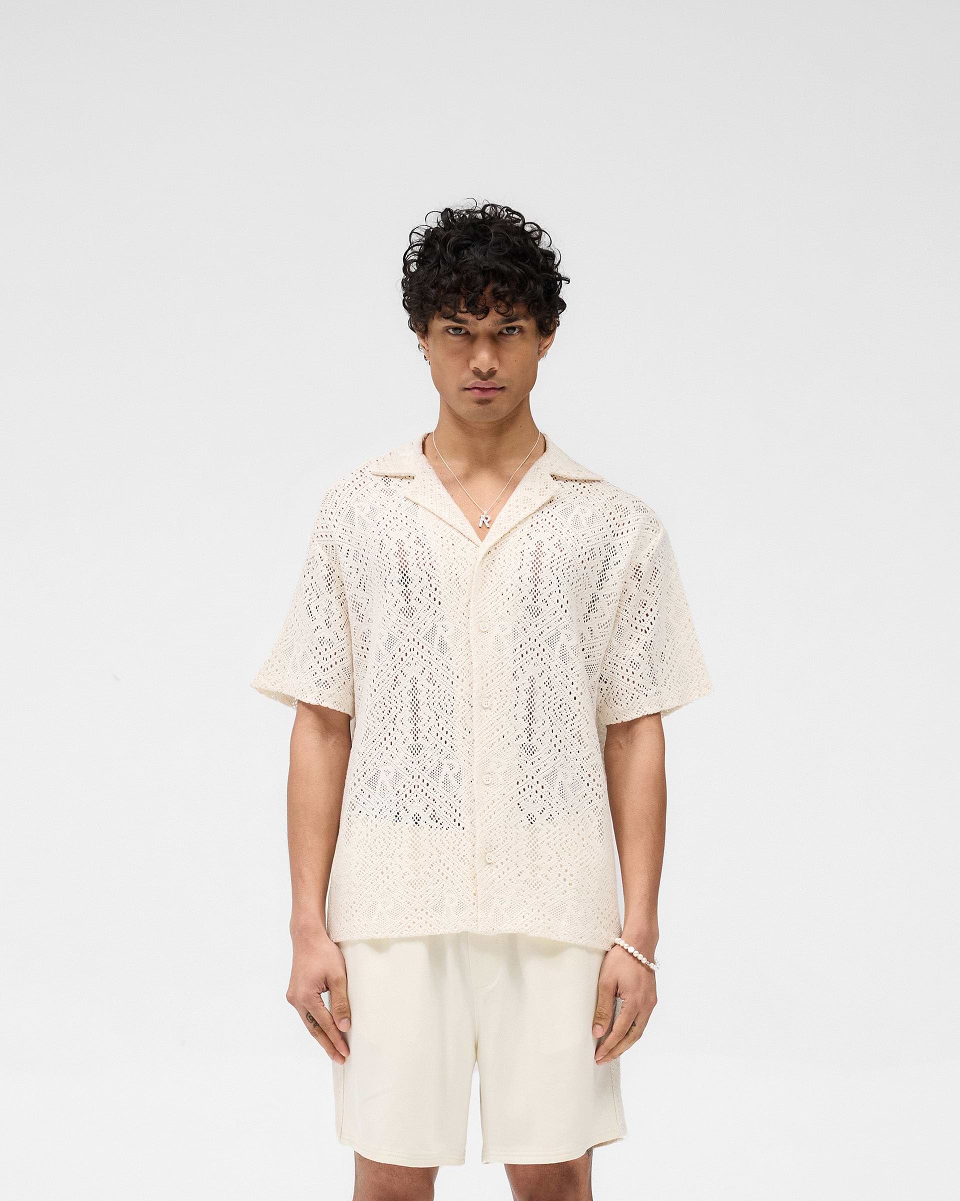 Man wearing an off-white crochet shirt on a plain white background | All Over Crochet Shirt in Off White | Open-knit crochet shirt with