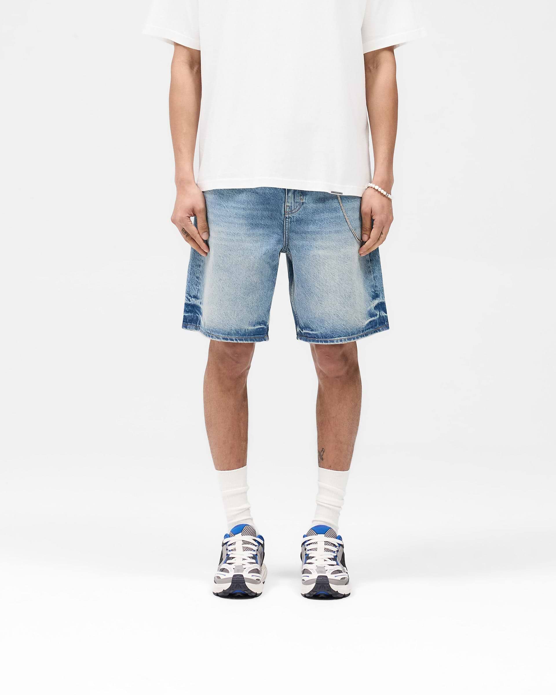 Man wearing blue denim shorts on a plain white background | R10T Tailored Denim Shorts in Blue 60 | Tailored fit mid-length denim shorts | SS25 Denim | Represent Clo