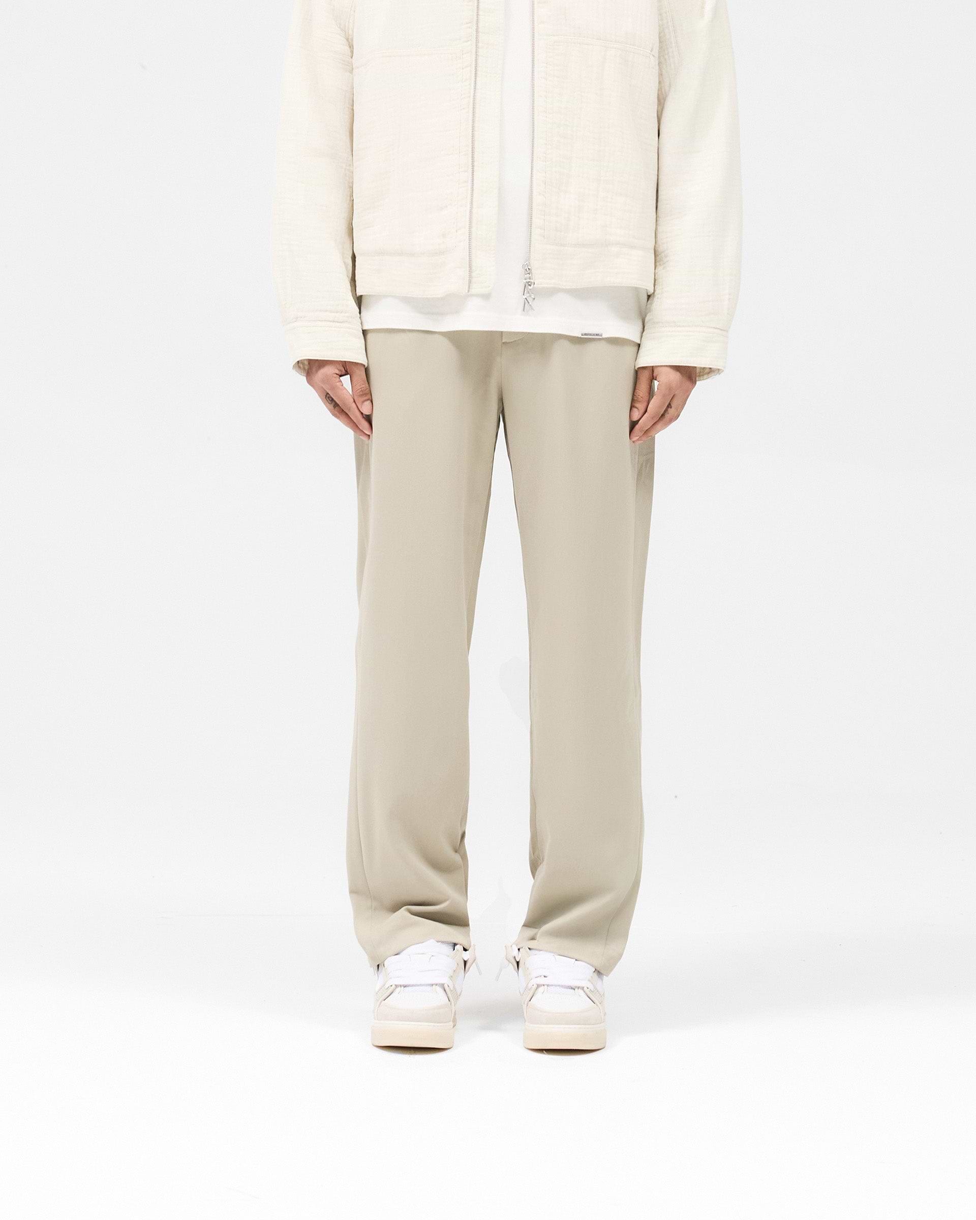 Man wearing light grey pants on a plain white background | Core Pant in Light Grey | Pants with hybrid-style waistband and elasticated section | SS25 Pants | Represent Clo