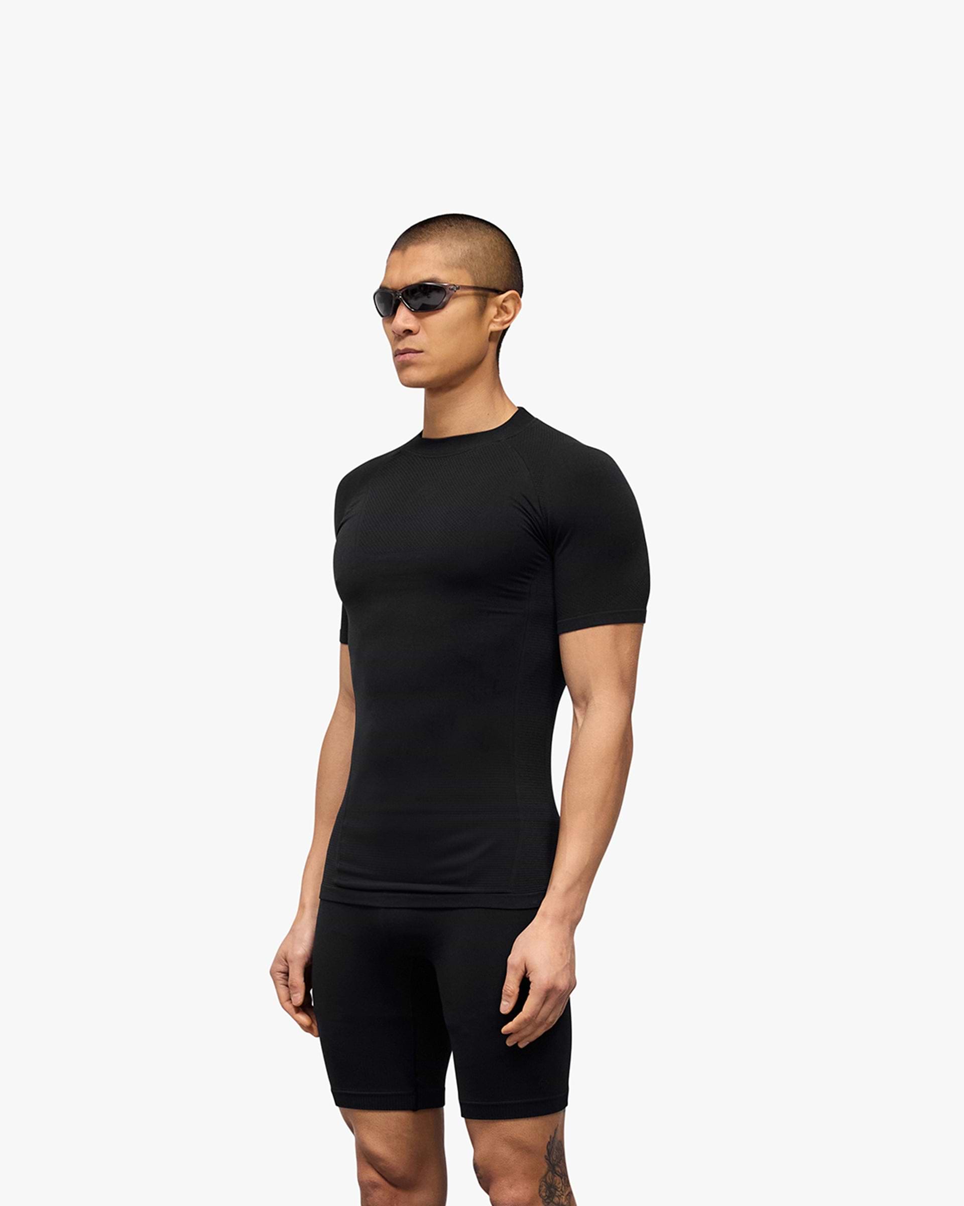 Man wearing a black seamless t-shirt on a plain white background | 247 DNA Seamless T-Shirt in Black | Slim fit t-shirt with engineered knit zones | 247 T-Shirts | Represent Clo