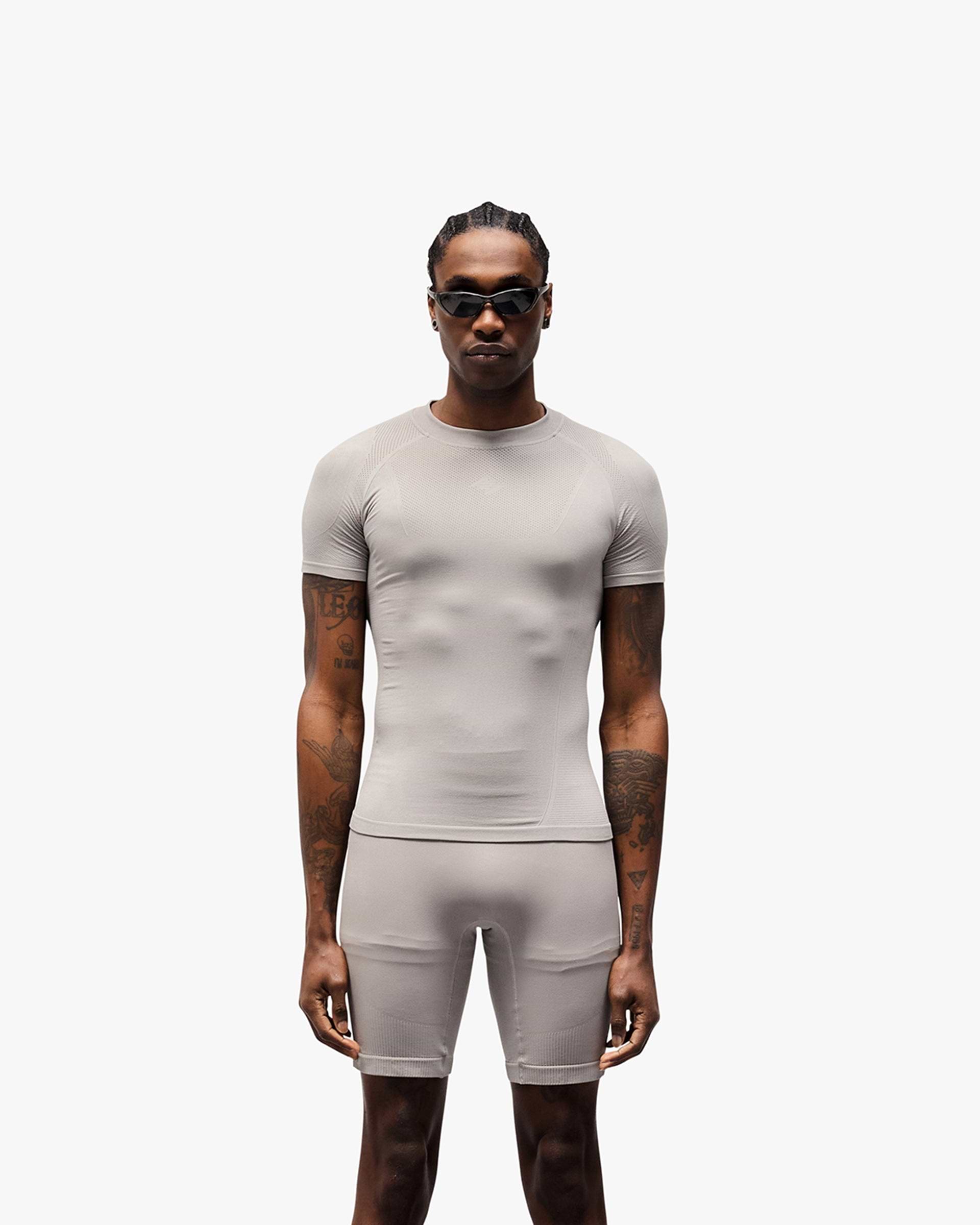 Man wearing a grey t-shirt on a plain white background | 247 DNA Seamless T-Shirt in Titanium | Slim fit t-shirt optimising airflow | 247 T-Shirts | Represent Clo