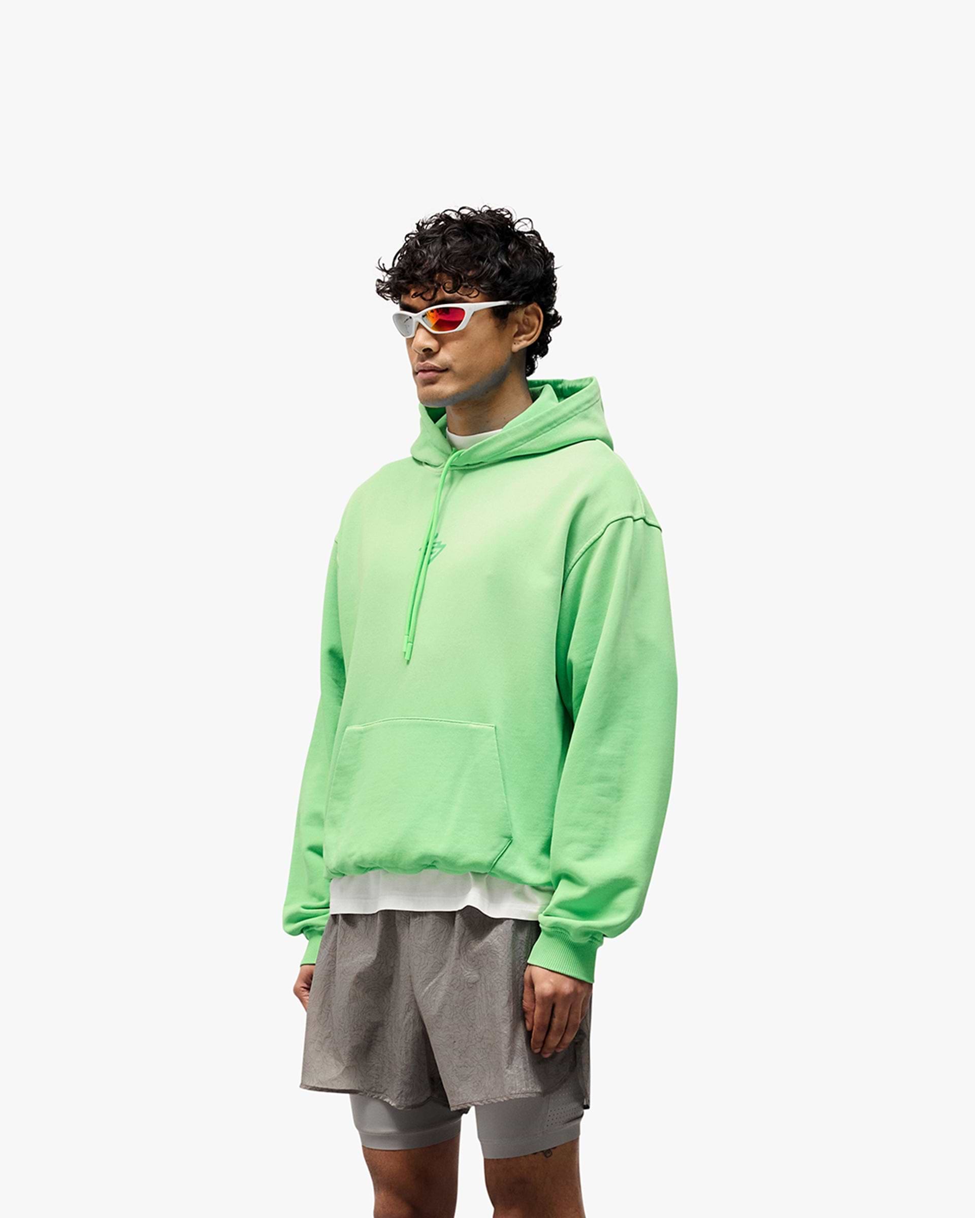Man wearing an oversized green hoodie on a plain white background | 247 Motion Oversized Hoodie in Speed Green | Oversized hoodie with ribbed hem and cuffs | 247 Hoodies | Represent Clo