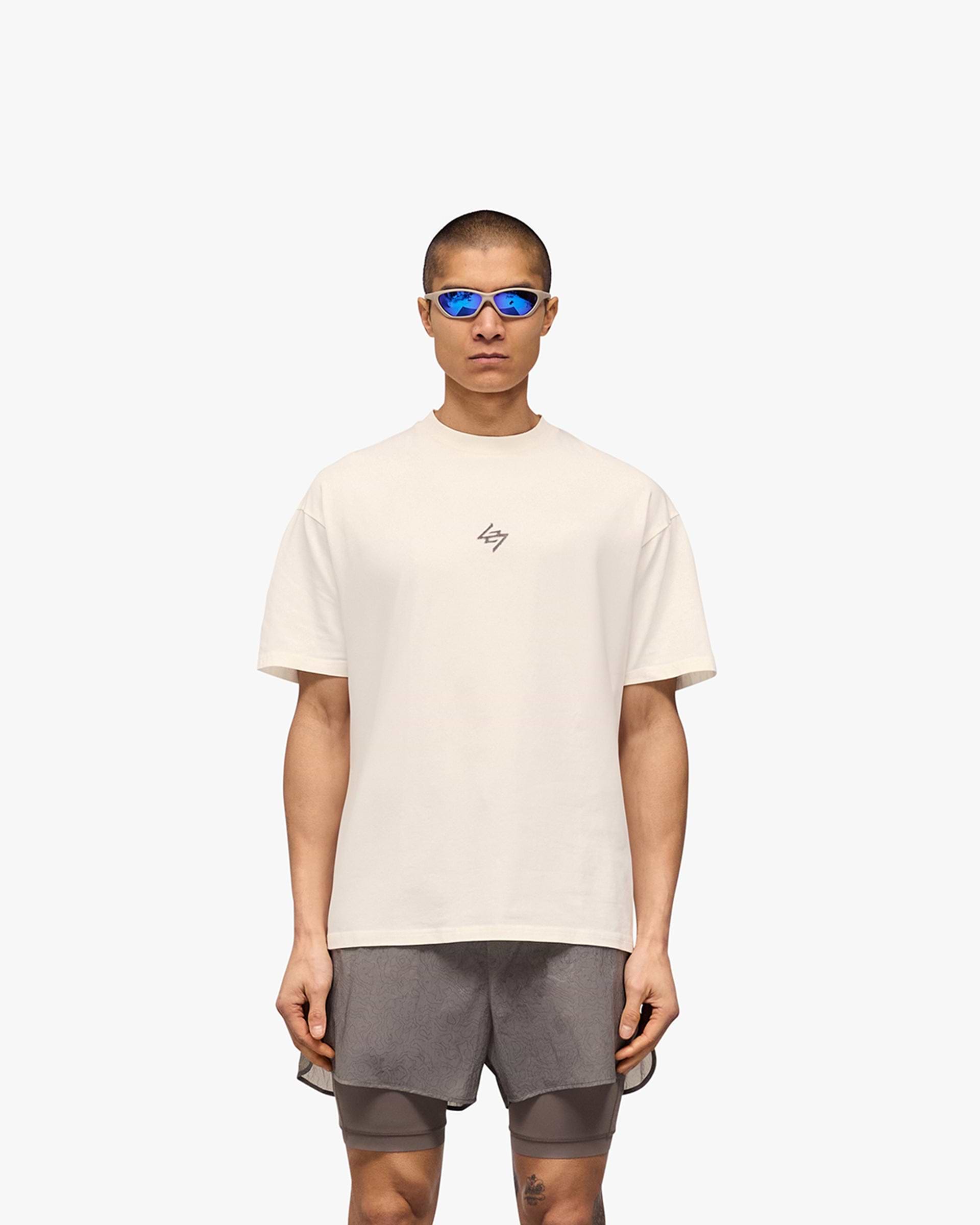 Man wearing an oversized white t-shirt on a plain white background | 247 Motion Oversized T-Shirt in Flat White | T-Shirt with 2 way stretch and sweat wicking | 247 T-Shirts | Represent Clo