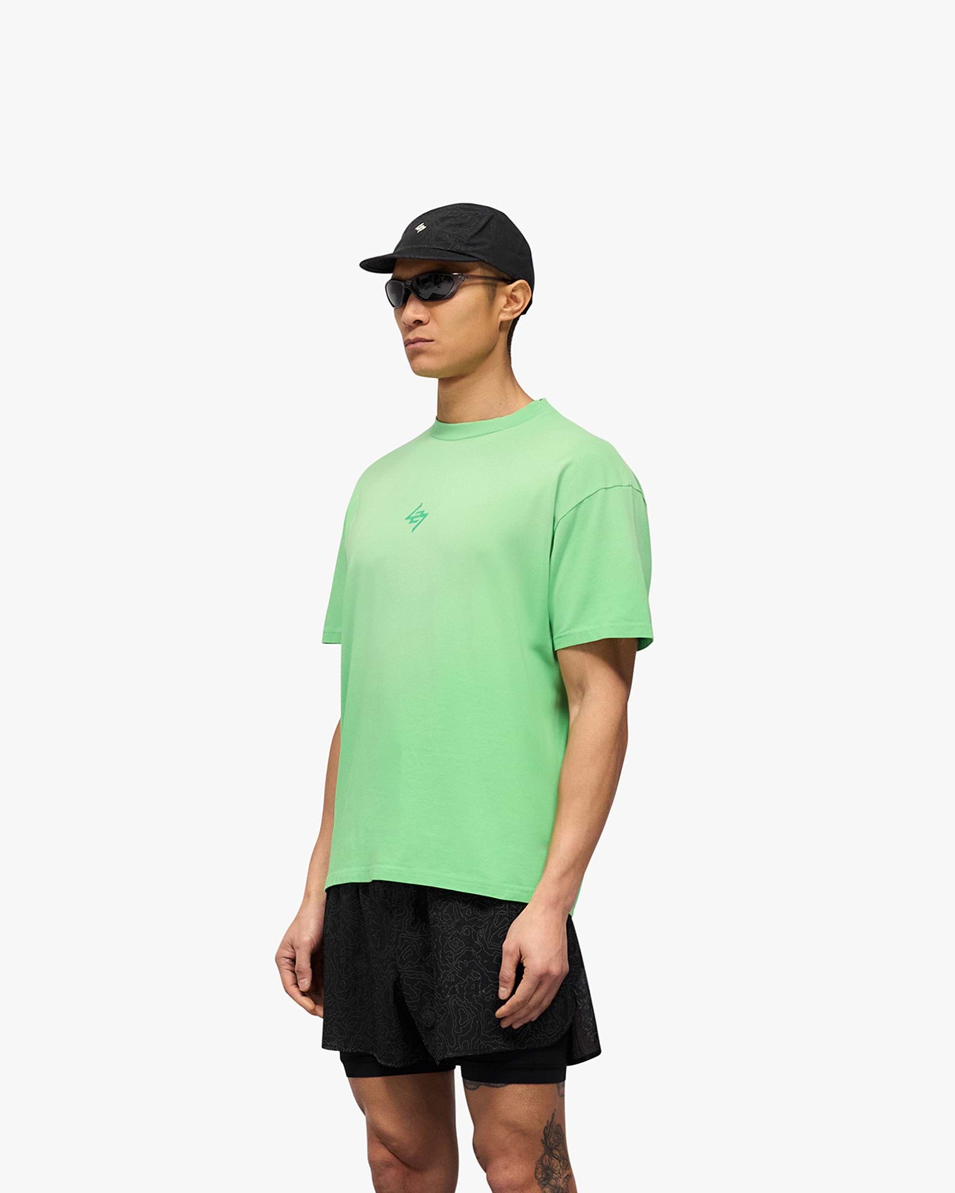 Man wearing an oversized green t-shirt on a plain white background | 247 Motion Oversized T-Shirt in Speed Green | T-Shirt with 2-way stretch and graphic prints | 247 T-Shirts | Represent Clo